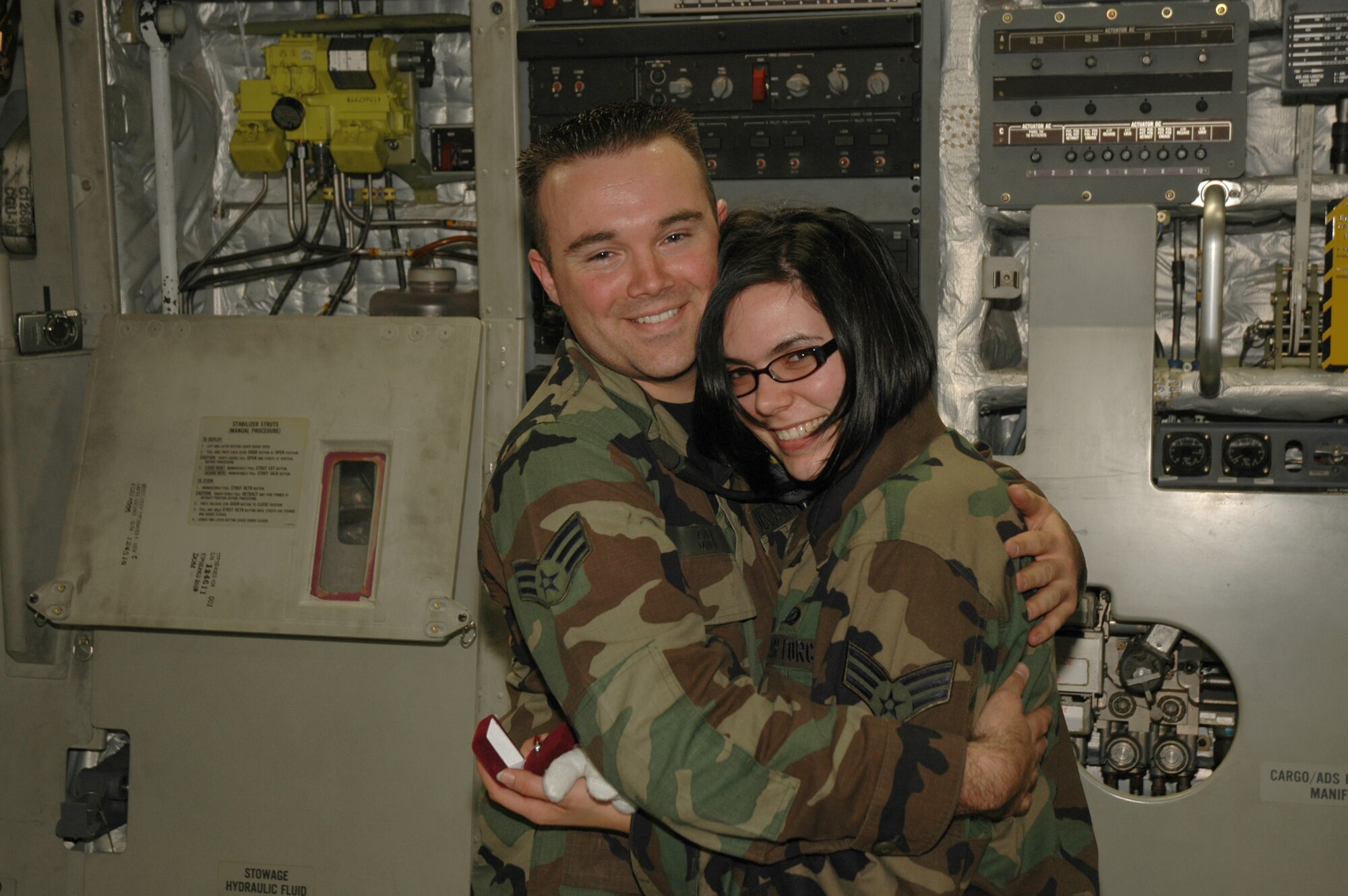 Romance is in the air (and in the jet) -- Senior Airman Chris Shea, with the 315th Aircraft Maintenance Squadron, proposes to Senior Airman Dani Pacheco, 315th Public Affairs, in the back of a C-17 Globemaster III.  Both reservists are members of the 315th Airlift Wing at Charleston AFB, S.C. (Photo by Tech. Sgt. Mark Kleber, USAFR)