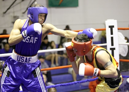 Andre Penn, left, from Ellsworth AFB, S.D., punches Ruben Gutierrez from Marine Corps Base, Kaneohe Bay, Hawaii, during the Armed Forces Boxing Championship preliminary bouts March 7 at the Bennett Fitness Center at Lackland Air Force Base, Texas. Penn won by retirement. (USAF photo by Robbin Cresswell)