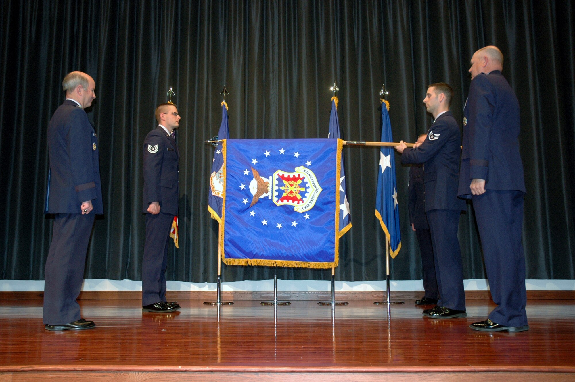 The new flag to the USAF EC is unfurled during a special ceremony at the center Monday at Fort Dix. Observing the flag unfurling are Gen. Duncan J. McNabb, AMC commander, and Maj. Gen. Scott Gray, USAF EC commander.
