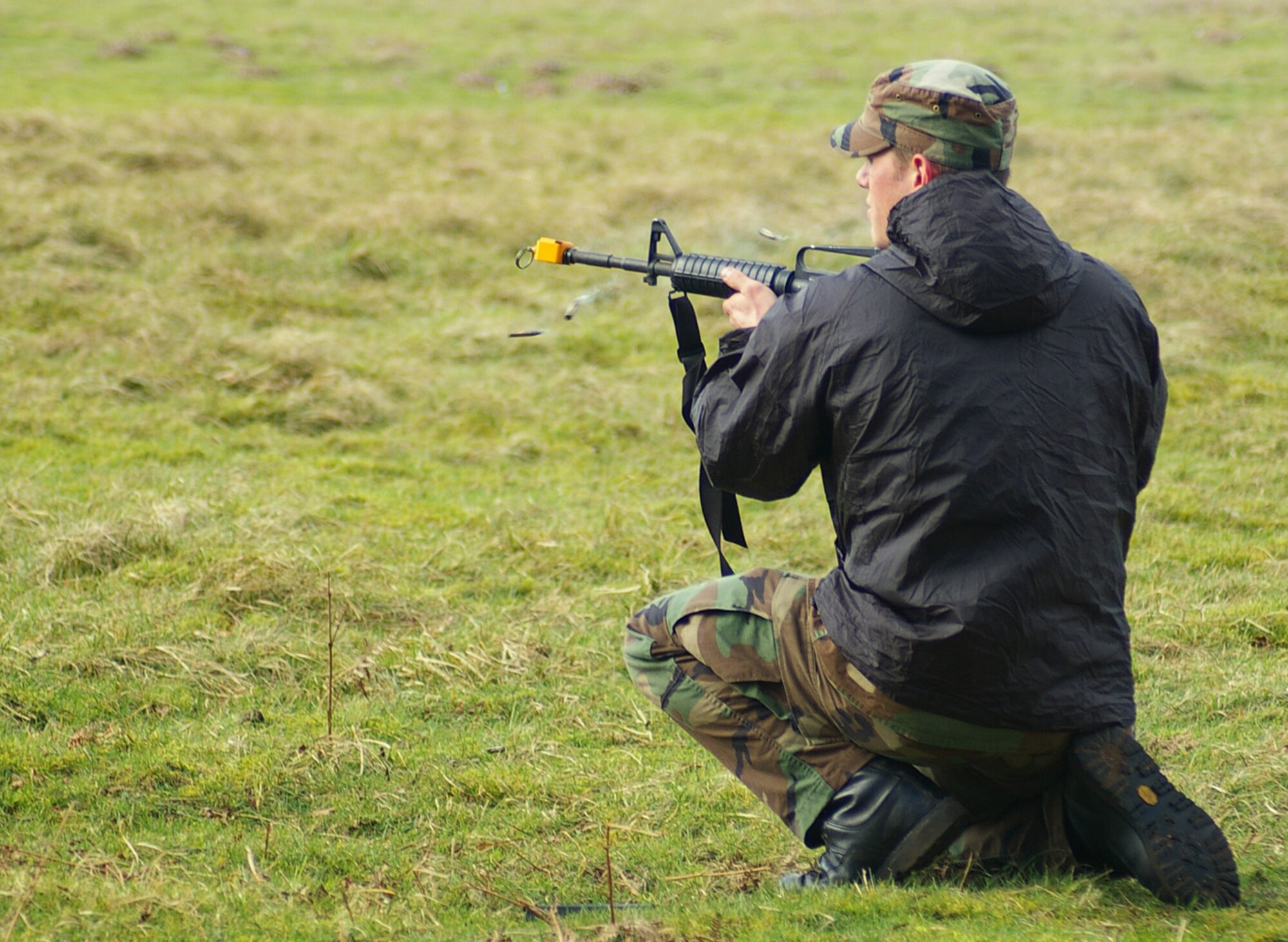 A Survival, Evasion, Resistance, Escape specialist plays the part of an aggressor as he open fires (blank rounds) on troops from the 100th Air Refueling Wing and 48th Fighter Wing during acombat survival training exercise March 6 at Stanta training range, near Thetford, England. (U.S. Air Force photo by Karen Abeyasekere)