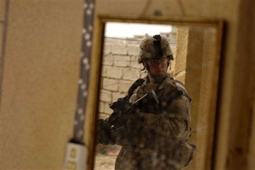 U.S. Army Pvt. Brian Kibbey provides security while Iraqi police search a house during a patrol of Riyahd, Iraq, led by the Iraqi police, March 6, 2007. Kibbey is assigned to 4th Platoon, Delta Company, 2nd Battalion, 27th Infantry Regiment, out of Schofield Barracks, Hawaii. 
