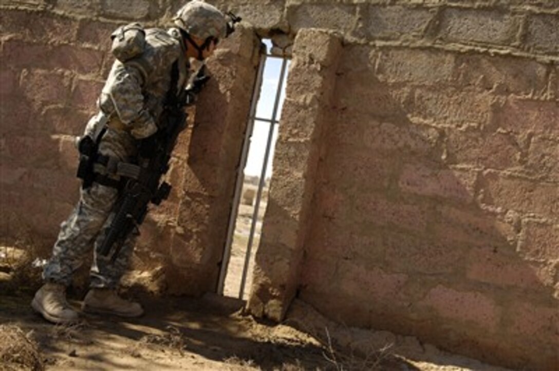 U.S. Army Sgt. William Lo looks for a sniper who has fired rounds in the area during a patrol led by Iraqi police in Riyahd, Iraq, on March 6, 2007.  Lo is assigned to 4th Platoon, Delta Company, 2nd Battalion, 27th Infantry Regiment.  
