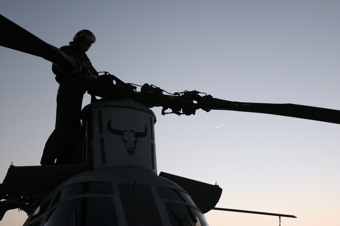 Lance Cpl. Michael A. Thomas, a CH-46E Sea Knight crew chief with Marine Medium Helicopter Squadron 261, and an Orange County, Calif., native, works into the evening to secure his aircraft aboard Marine Corps Air Station New River, N.C., March 8, 2007.  The Marines and sailors of HMM-261 are currently training as the Aviation Combat Element for the 22nd Marine Expeditionary Unit scheduled to deploy later this year.  (U.S. Marine Corps photo by Cpl. Peter R. Miller)