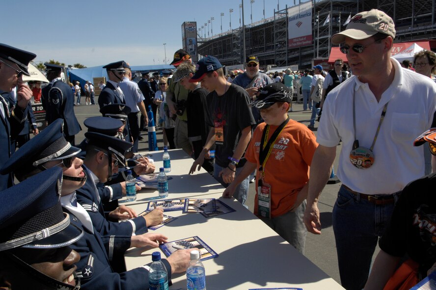 The United States Air Force Honor Guard Drill Team autographs AF recruiting posters after their performance at the Las Vegas Motor Speedway, Las Vegas, Nev., March 10, 2007. The Drill Team is the traveling component of the Air Force Honor Guard and tours Air Force bases world wide showcasing the precision of today's Air Force to recruit, retain, and inspire Airmen for the Air Force mission. (U.S. Air Force photo by Airman 1st Class Rusti Caraker)(Released)