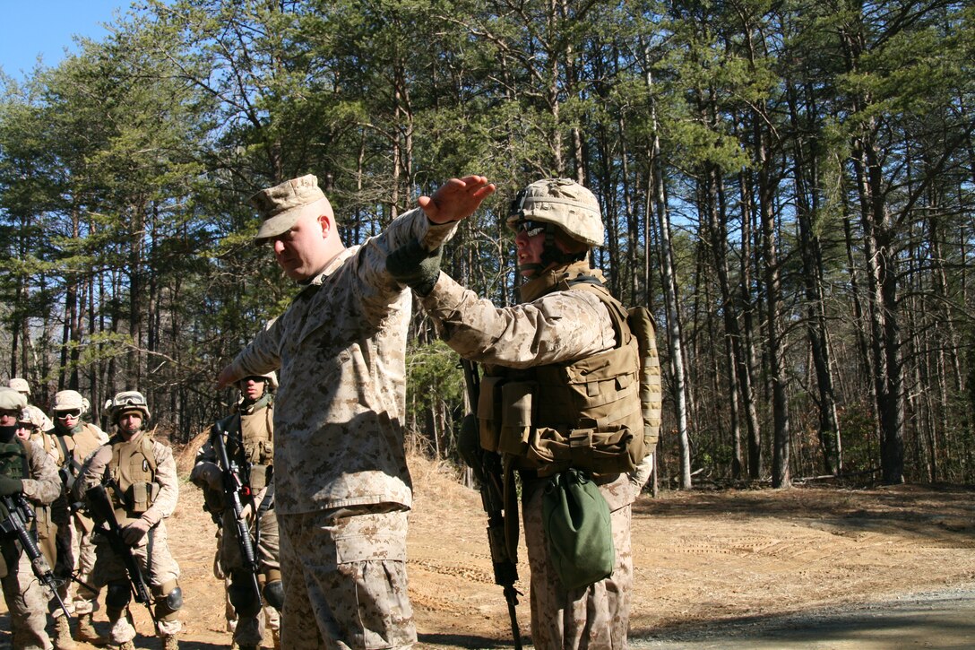 Sgt. Eric Hollenstein demonstrates proper personnel search techniques on Sgt. Raymond Elwell, a Company F fixed-site security instructor, during the entry control point portion of training March 11.