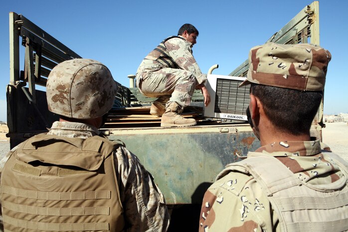 HABBINIYAH, Iraq - An Iraqi soldier loads an air conditioner on the back of his truck here March 11. The 1st Motor Transportation Regiment, 1st Iraqi Army Division provides transportation support for the division as well as many other logistical capabilities to support the Iraqi soldiers on the ground.