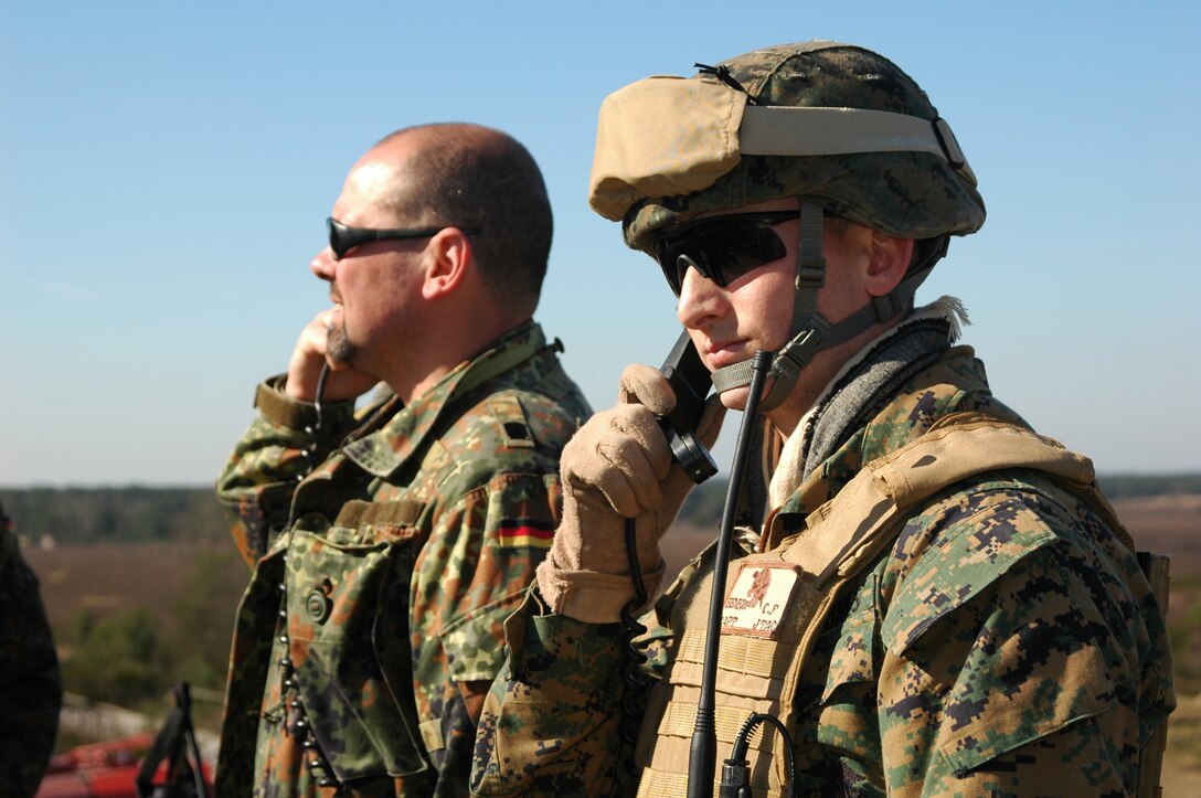 Captain Charles F.  Benbow, fire power control team leader, 2nd Air and Naval Gunfire Liaison Company, II Marine Expeditionary Force, stands alongside a German soldier during exercise Combined Thunder here at the Munster South Training Area near Hamburg, Germany, March 12. Approximately 40 Marines and Sailors deployed to Germany to take part in exercise Combined Thunder taking place 1 to 18 March. During the exercise the Marines and Sailors worked along side German soldiers assigned to the Panzer Artillery Regiment 100 and Panzer Artillery Battalion 125 conducting various fire support training events.