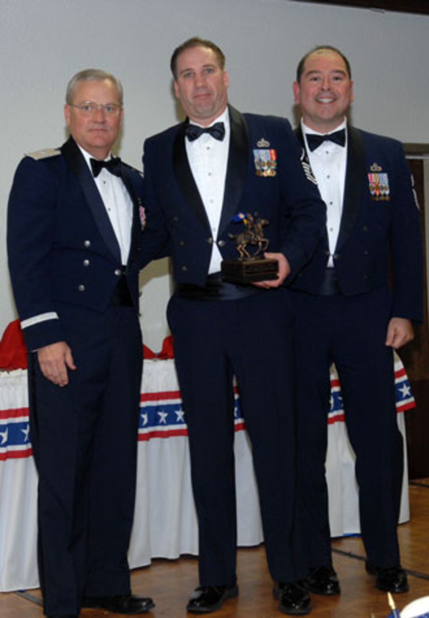 Brig. Gen. James L. Melin, 452nd AMW commander, presents the First Sergeant of the Year award to Master Sgt. Mark Magill, 452 SVS.  Also congratulating Master Sgt. Magill is 452nd AMW Command Chief Master Sgt. Agustin Huerta, right.  The 452d Air Mobility Wing's 13th Annual Awards Banquet recognized the men and women in the wing who have made a difference in 2006. The banquet was held at March Air Reserve Base in February.  (U.S. Air Force photo by 4th Combat Camera)