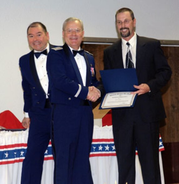 Brig. Gen. James L. Melin, 452nd AMW commander, presents the GS-07 through GS-11 Civilian of the Year award to Mr. Cary Kerr, 452 SVS.  Also congratulating Mr. Kerr is 452nd AMW Command Chief Master Sgt. Agustin Huerta, left.  The 452d Air Mobility Wing's 13th Annual Awards Banquet recognized the men and women in the wing who have made a difference in 2006.   The banquet was held at March Air Reserve Base in February.  (U.S. Air Force photo by 4th Combat Camera)