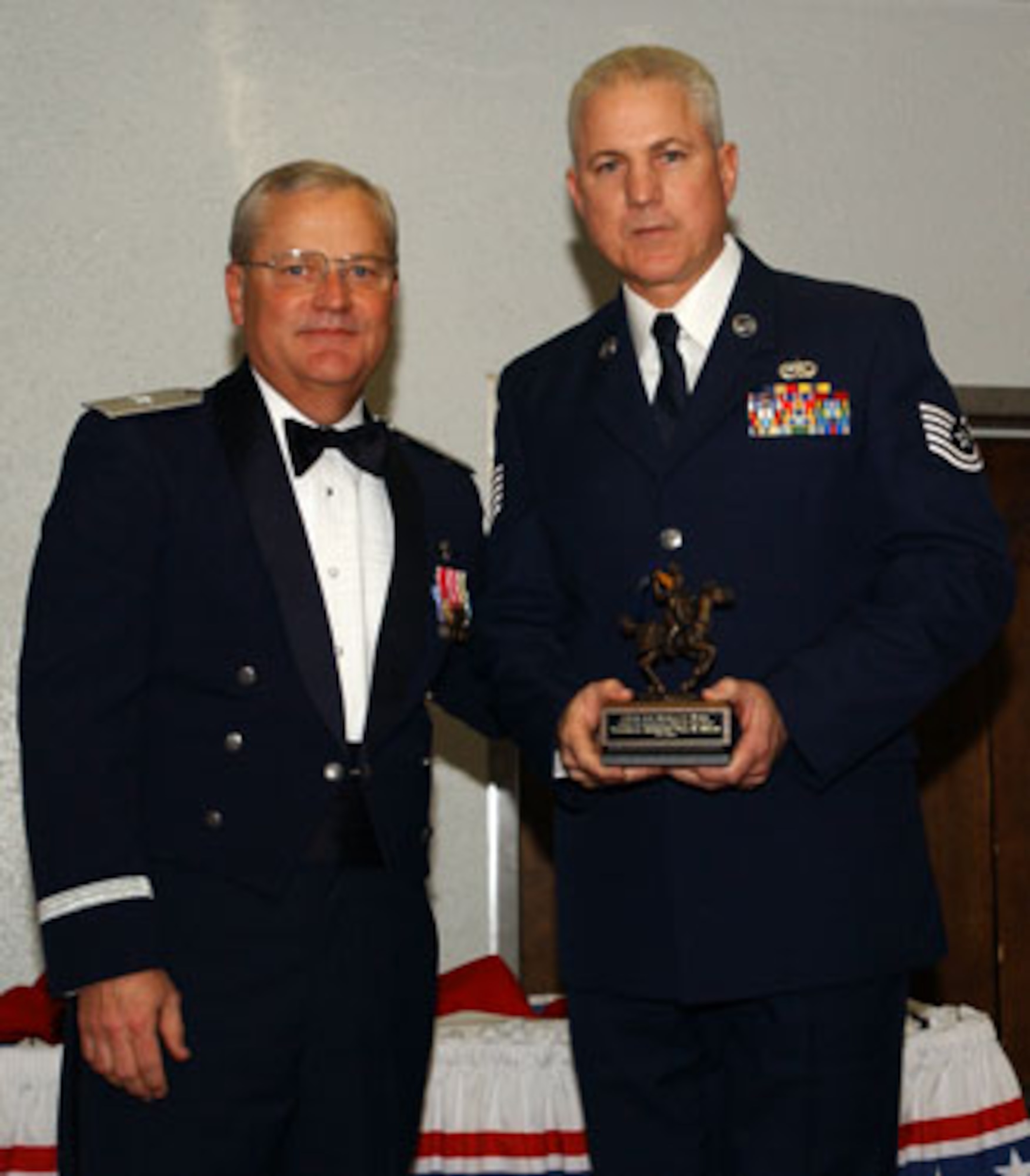 Brig. Gen. James L. Melin, 452nd AMW commander, presents the NCO of the Year award to Tech. Sgt. Paul Bixler, 452 MXS. The 452d Air Mobility Wing's 13th Annual Awards Banquet recognized the men and women in the wing who have made a difference in 2006.   The banquet was held at March Air Reserve Base in February.   (U.S. Air Force photo by 4th Combat Camera)
