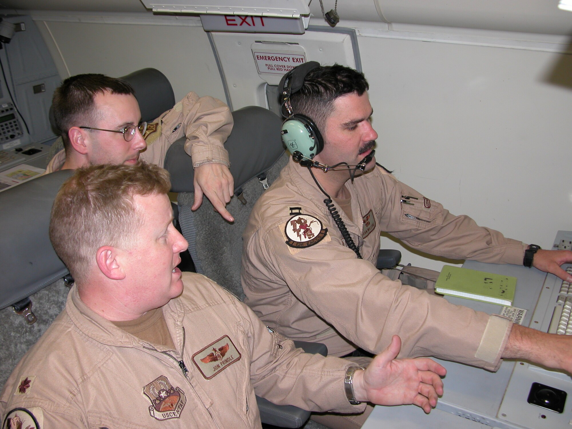 Army Staff Sgt. Tim Harris, 128th Expeditionary Airborne Command and Control Squadron Airborne Target Surveillance supervisor (center), reviews a JSTARS track with fellow aircrew members Maj. Jon Pindle (left) and Capt. Dan Willems during a recent mission. Together, the Air Force and Army aircrew provide a comprehensive look at the “ground picture” of radar targets in Iraq, and report the information to multiple locations throughout the theater using several advanced datalinks. Developing a common understanding of the situation helps JSTARS ensure the best possible radar top cover to coalition forces in Operation Iraqi Freedom. (U.S. Air Force photo)