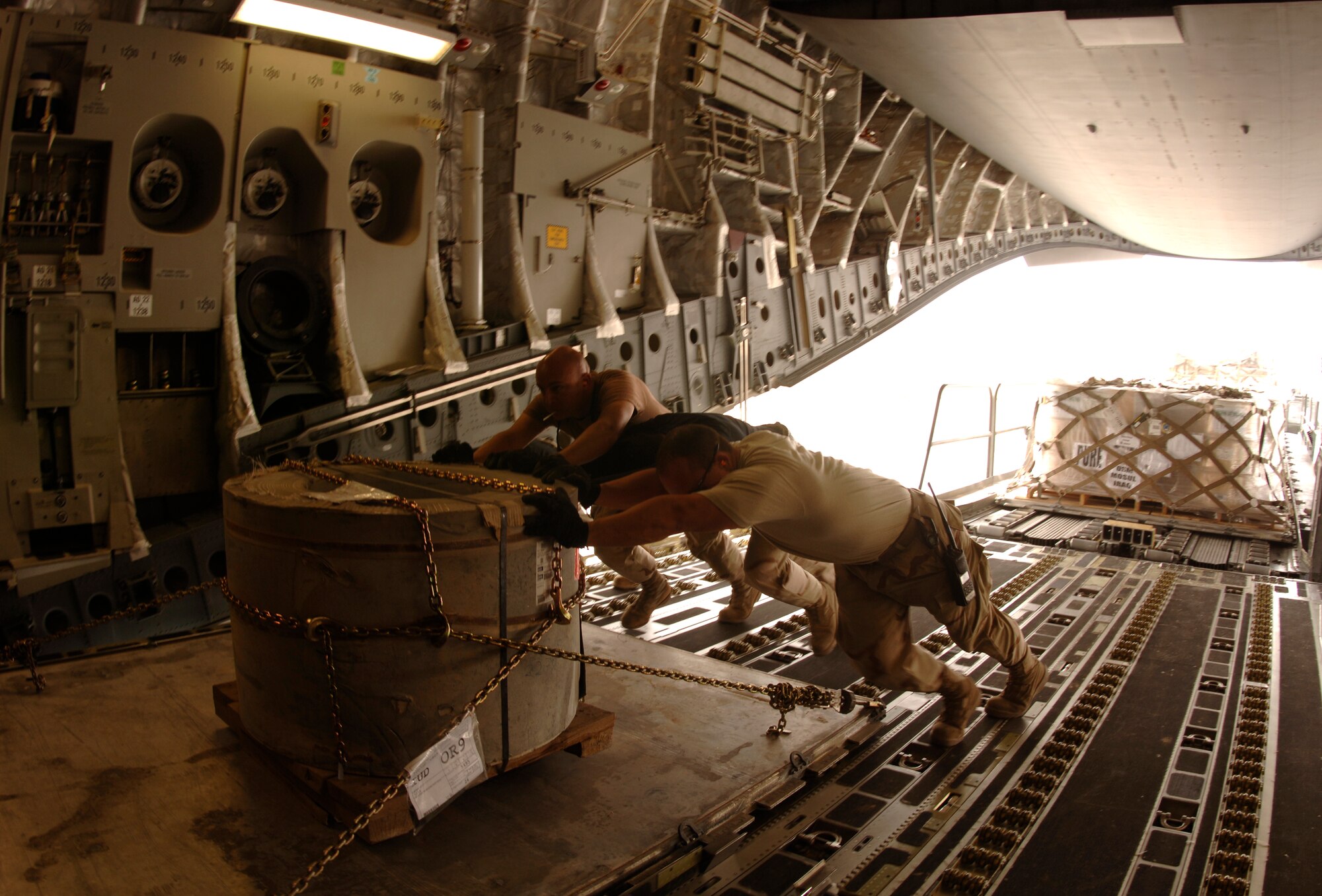 Aerial porters from the 8th EAMS load palletized cargo onto a C-17 for intratheater shipment. The cargo sits on rollers on the ramp and is pushed in from a 60K loader. The squadron processes about 250,000 pounds of cargo for intertheater and intratheater shipment each day. (U.S. Air Force photo by Staff Sgt. David Miller)