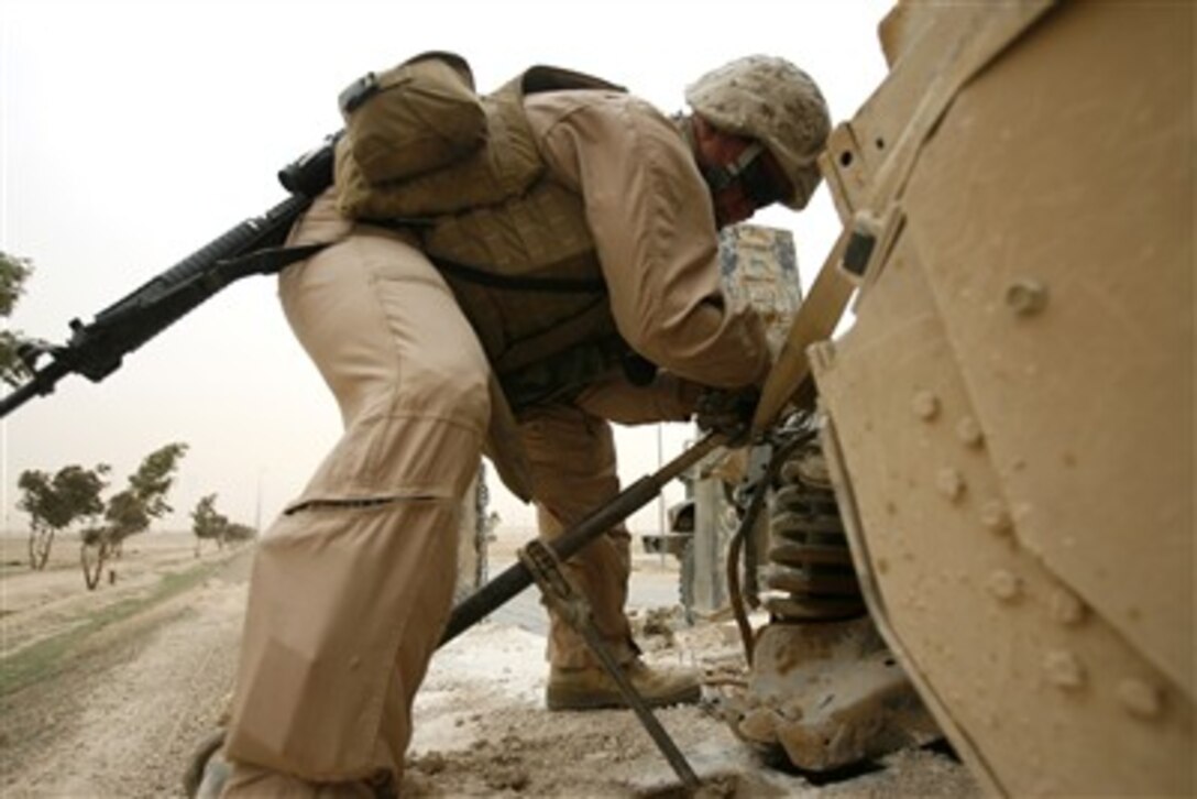 Cpl. Michael Sawatzky, a 24-year-old motor transport operator from Aberdeen, S.D., binds down a damaged humvee that Motor-T Marines from the Camp Lejeune, N.C.-based, 2nd Light Armored Reconnaissance Battalion lifted onto his vehicle, Feb. 24, 2007, near Baghdad.