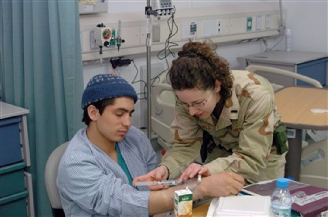 Medical nurse 1st Lt. Karis Russell flushes the IV in patient Rahmat Shah's arm March 4 at the Craig Joint-Theater Hospital in Bagram, Air Base, Afghanistan. Patients were moved from the original task force medical hospital to the new facility earlier that day. 