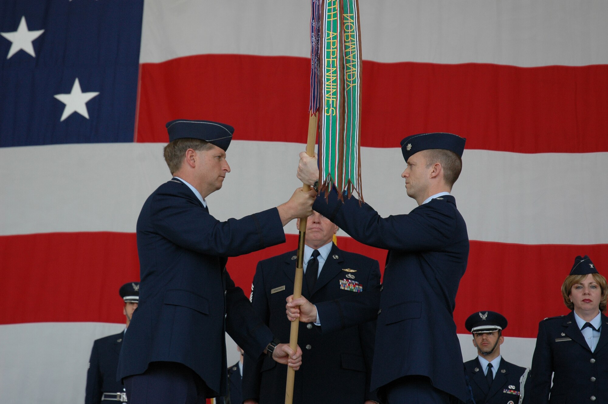 Col. Derek Rydholm (left) passes the 302nd Fighter Squadron flag to Lt. Col. Hubie Hegtvedt during a 302nd FS symbolic transfer ceremony on March 10, 2007. Colonel Rydholm is the 944th Fighter Wing commander, a reserve unit at Luke Air Force Base, Ariz. Colonel Hegtvedt is chief of the F-22 program integration office at Elmendorf AFB, Alaska. As part of Base Realignment and Closure, the 302nd FS will realign to become a reserve F-22 unit at Elmendorf. (U.S. Air Force photo/Staff Sgt. Susan Stout)
