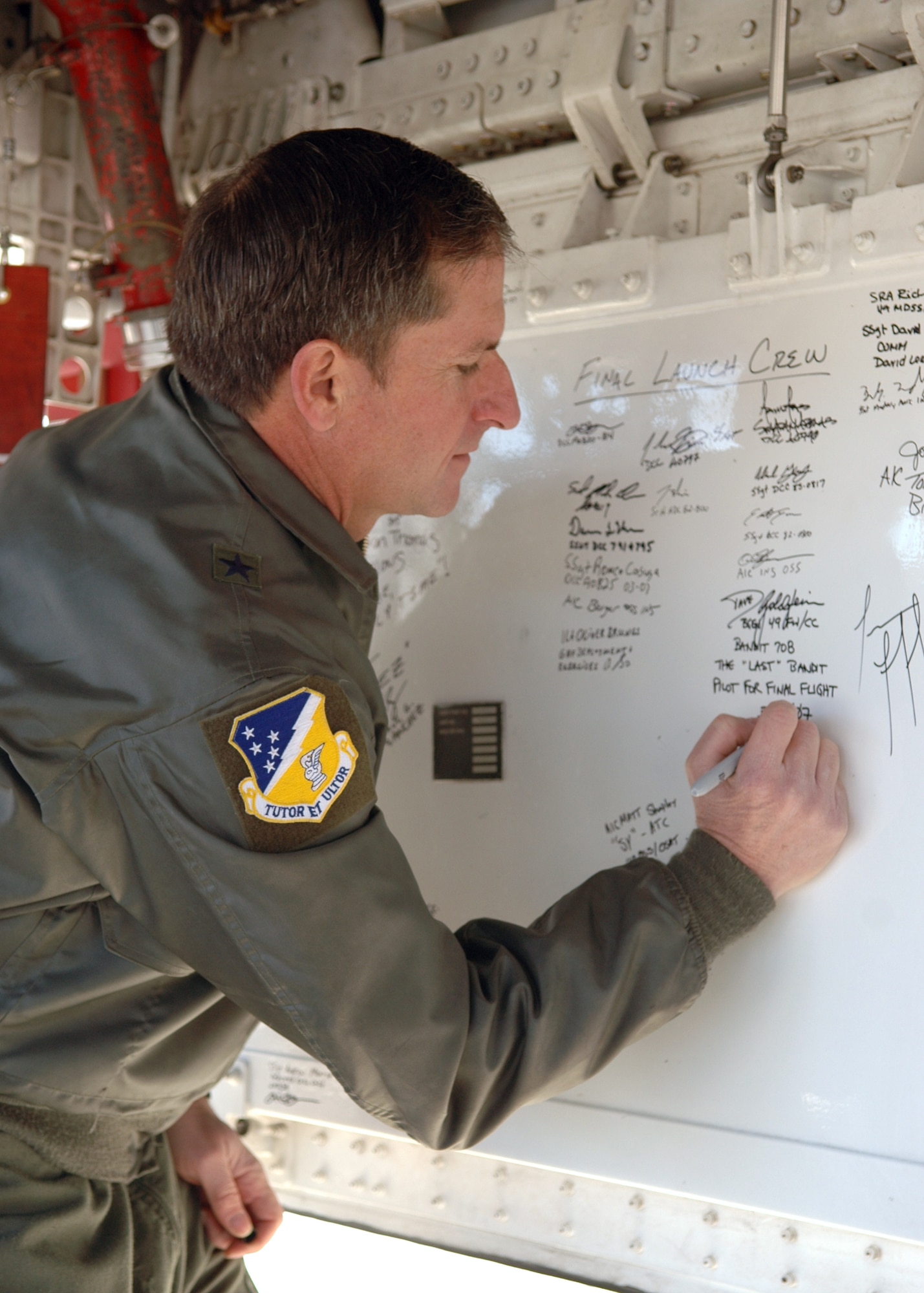 Brig. Gen. David Goldfein, 49th Fighter WIng commander, signs the bay door of one of the retiring F-117A Nighthawks. Six Nighthawks retired to Tonopah Test Range, Nev., March 12. (U.S. Air Force photo by Airman Jamal Sutter)