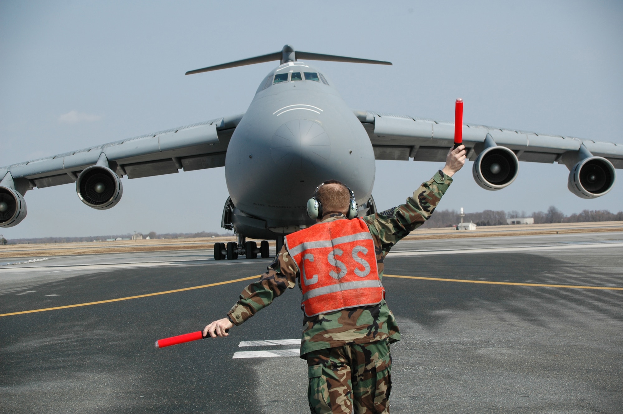 Tech. Sgt. James Baker, 512th Aircraft Maintenance Squadron, gives the "all clear" for the 326th Airlift Squadron crew to park on the Dover Air Force Base, Del., runway March 10. It was the last C-5 Galaxy flight for the 326th AS, a unit in the Air Force Reserve Command's 512th Airlift Wing. The squadron, which has been fliying the C-5 since 1973, is transitioning to the C-17 Globemaster III, scheduled to arrive in June. (U.S. Air Force photo/Tech. Sgt. Veronica A. Aceveda)
