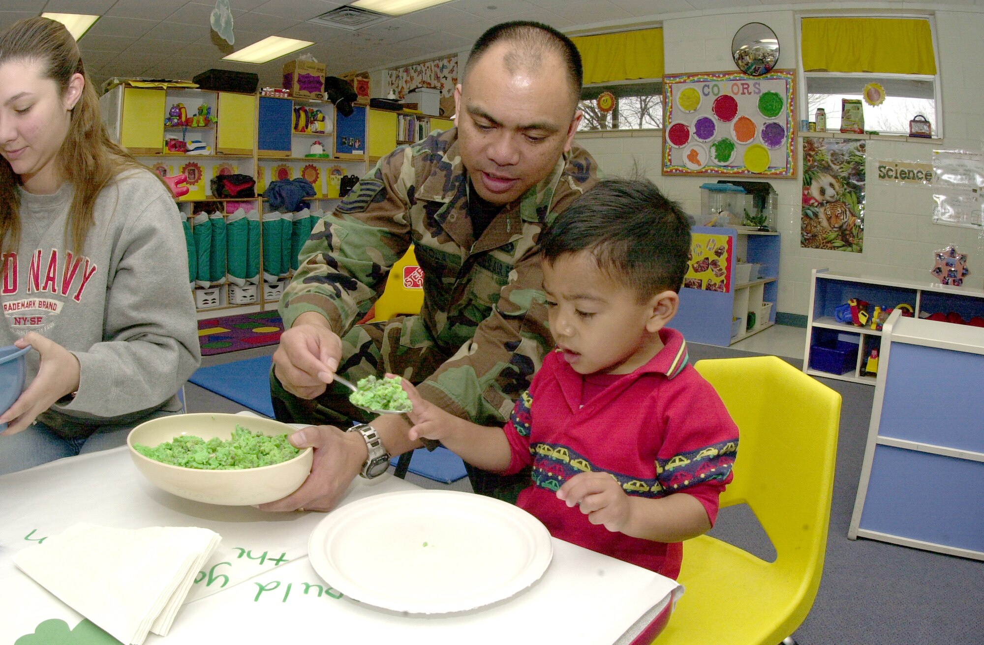 Tech. Sgt. Al Cachola serves his 2-year-old son Daniel a spoon full of green eggs and ham Mar. 2 at the base Child Development Center. The CDC hosted the “green” event as a way of observing St. Patrick’s Day, while encouraging parental involvement and education through reading.