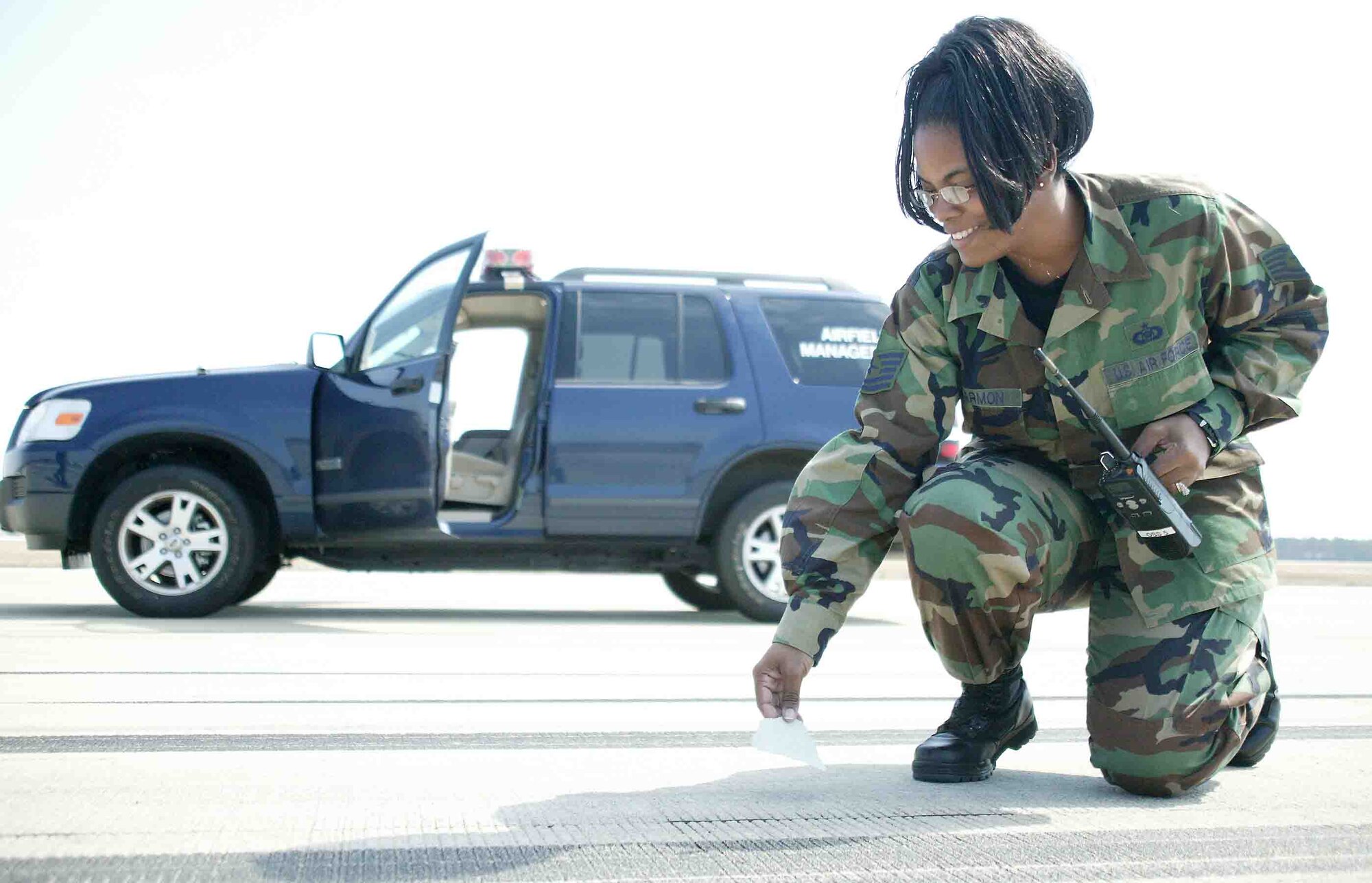 SHAW AIR FORCE BASE, S.C. -- Tech. Sgt. Contina Harmon, 20th Operations Support Squadron airfield management NCO in charge, picks up foreign object debris March 9 off Shaw's runway. FOD can be very hazardous to the aircraft and it is one of many duties airfield management performs. (U.S. Air Force photo/Senior Airman John Gordinier)
