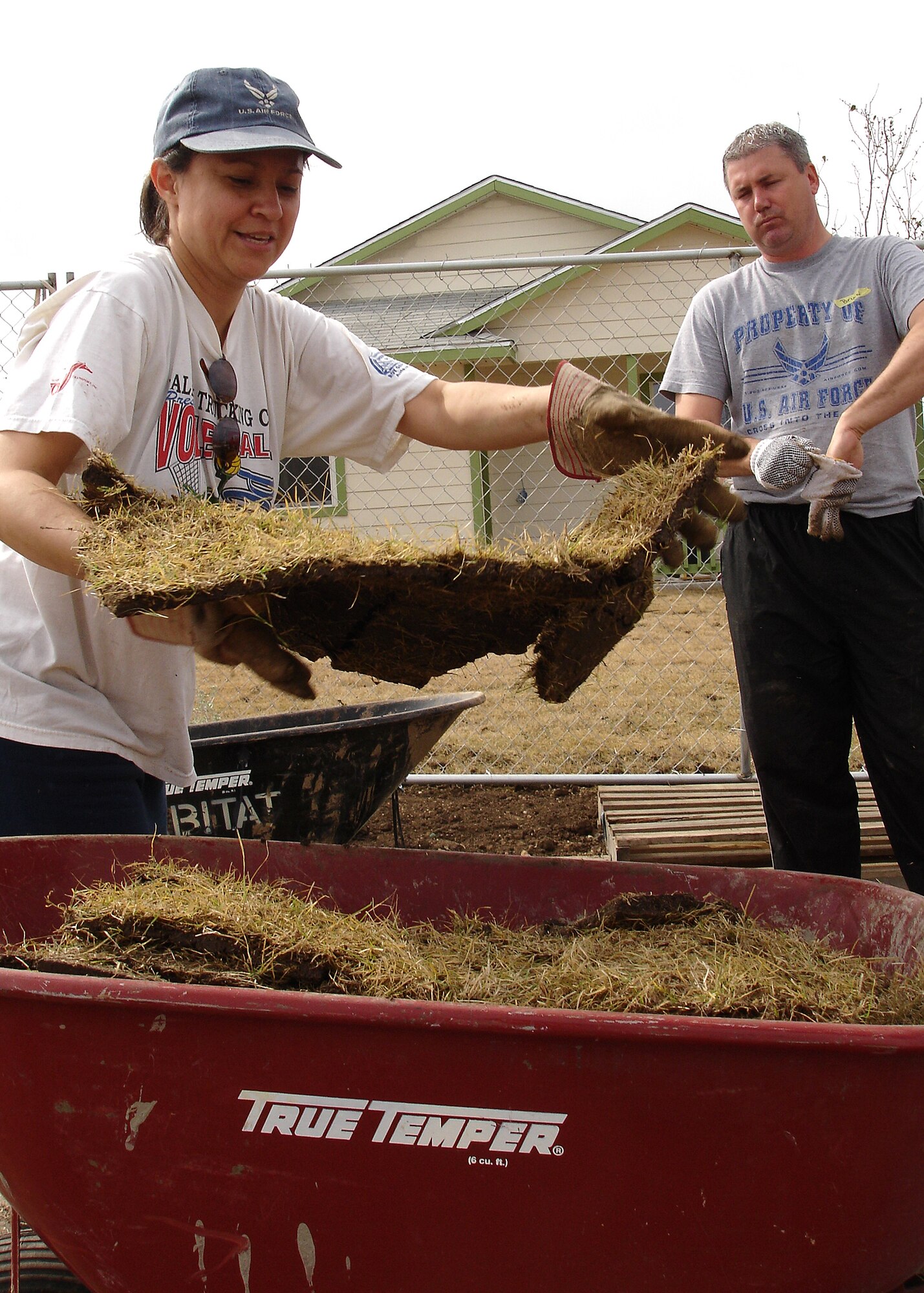Master Sgt. Toni Abrego pitches sod into a wheel barrow as Tech. Sgt. Larry Wright prepares to move the load to the backyard of a nearly completed Habitat for Humanity home Saturday in San Antonio, Texas. The commander’s support staff senior NCO and AFRS marketing division special events NCO were two of 13 Air Force Recruiting Service Airmen and family members who volunteered to landscape the yard of one of several Palo Alto subdivision homes slated for completion in the next two weeks. Habitat for Humanity seeks volunteers each Saturday throughout the spring and summer to help build and landscape additional affordable homes for qualified low-income families. For volunteer information, visit www.habitatsa.org. (Photo by Staff Sgt. Jennifer Lindsey)