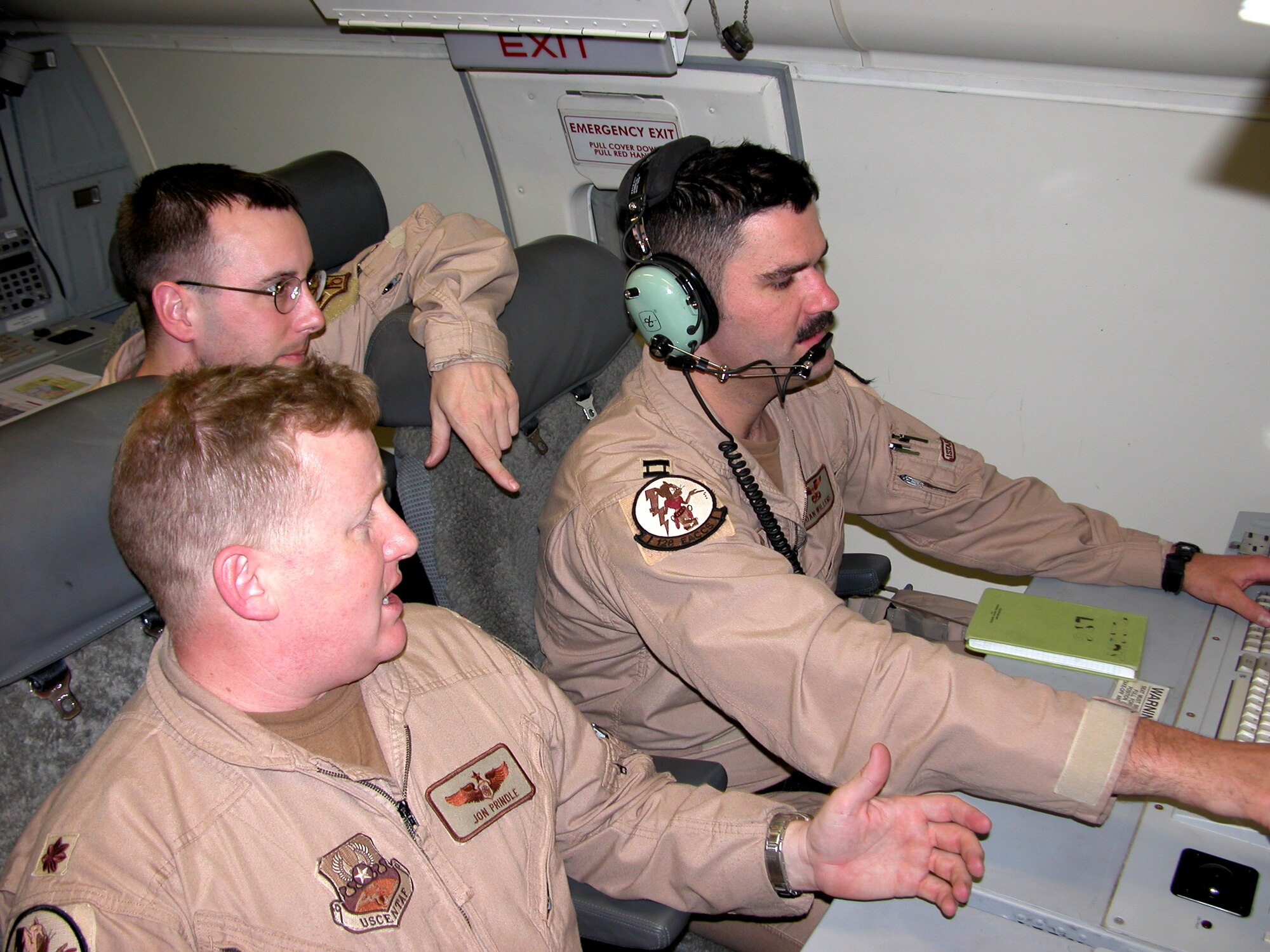 Army Staff Sgt. Tim Harris (center) reviews an E-8C Joint Surveillance Target Attack Radar System aircraft, or JSTARS, track with fellow aircrew members Maj. Jon Pindle (left) and Capt. Dan Willems during a recent mission. The Air Force and Army aircrew team provide a comprehensive look at the ground picture of radar targets in Iraq, and report the information to multiple locations throughout the theater ensuring the best possible radar top cover for coalition forces in Operation Iraqi Freedom. The team is part of the 128th Expeditionary Airborne Command and Control Squadron Airborne Target Surveillance. (U.S. Air Force photo)