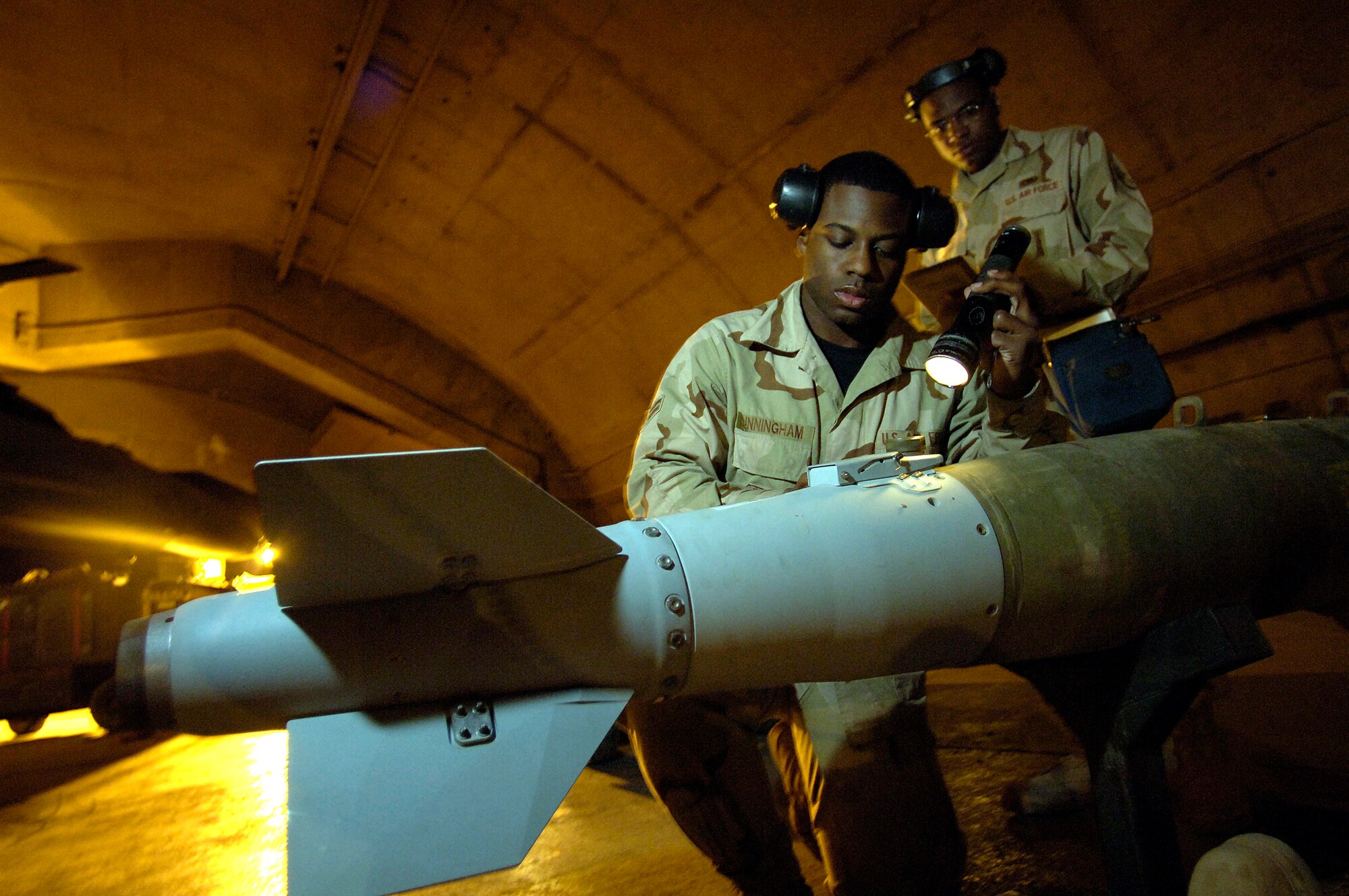 Staff Sgt. Christopher Curry and Airman 1st Class Brandon Cunningham prepare to load munitions on an F-16 Fighting Falcon March 4 at Balad Air Base, Iraq. The Airmen are assigned to the 332nd Expeditionary Aircraft Maintenance Squadron. (U.S. Air Force photo/Airman 1st Class Nathan Doza )