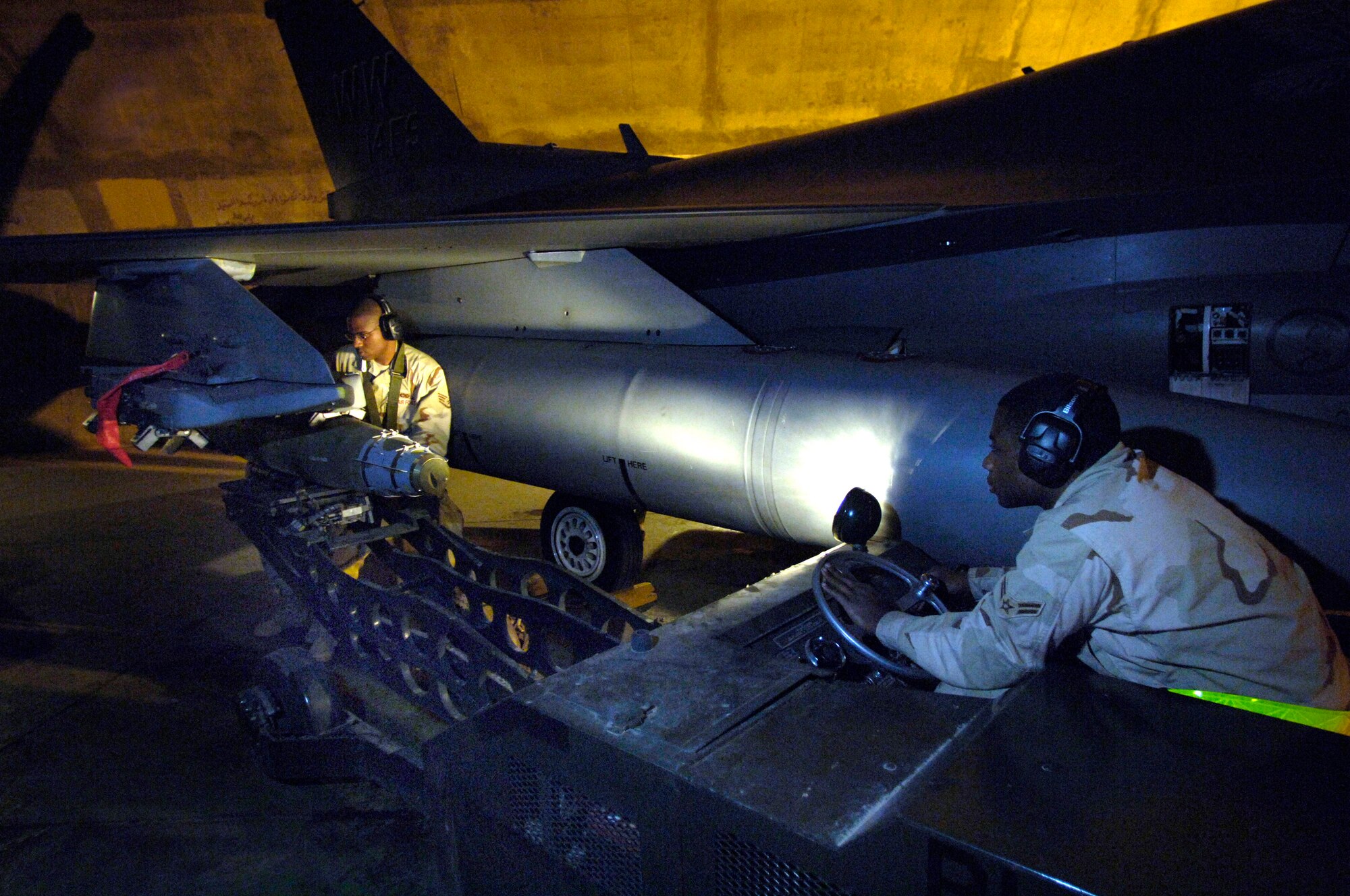 Staff Sgt. Christopher Curry and Airman 1st Class Brandon Cunningham prepare to load munitions on an F-16 Fighting Falcon March 4 at Balad Air Base, Iraq. The Airmen are assigned to the 332nd Expeditionary Aircraft Maintenance Squadron. (U.S. Air Force photo/Airman 1st Class Nathan Doza) 
