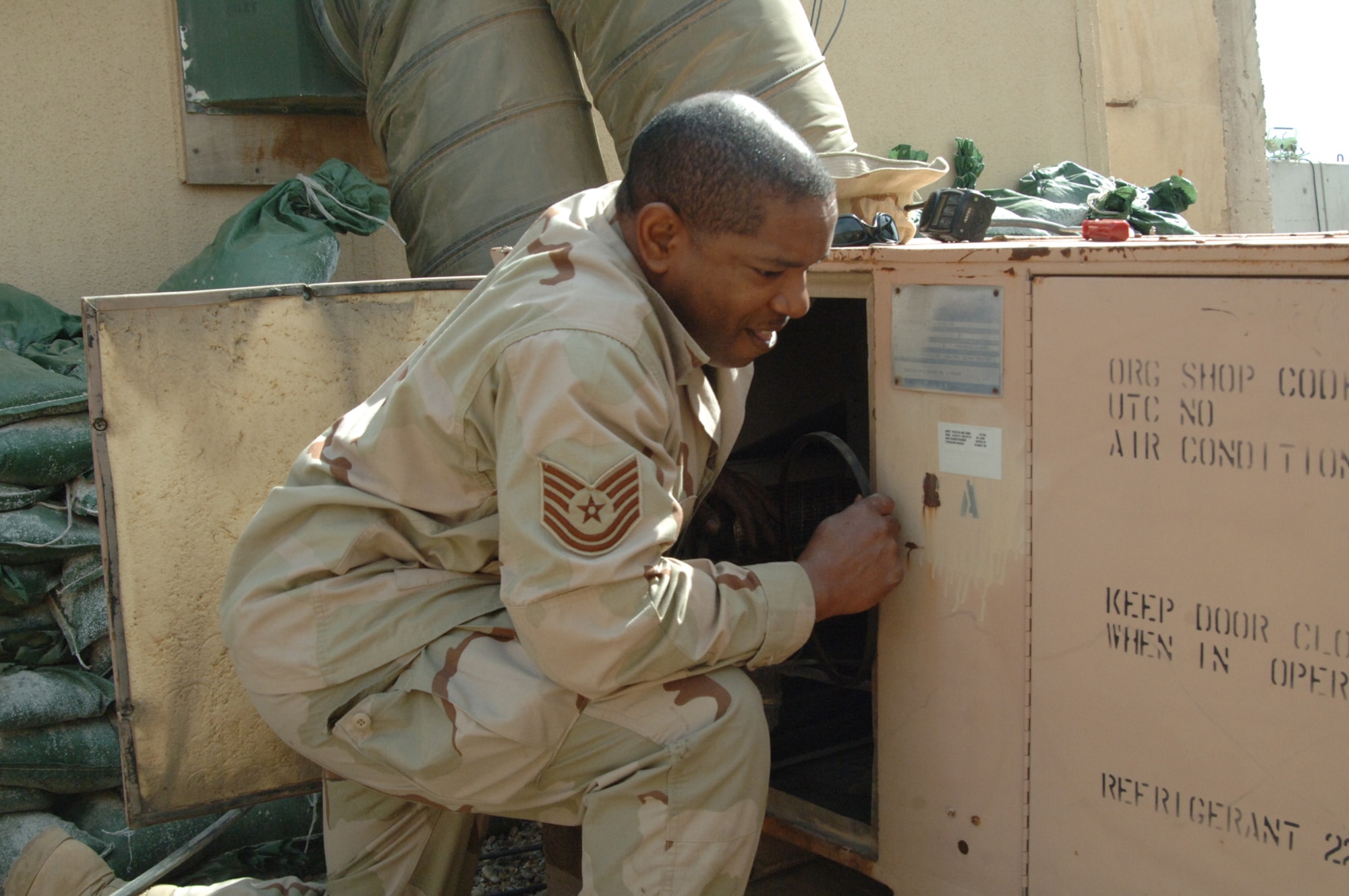 Balad Air Base, Iraq - Technical Sgt. Kelvin Curry, Heating, Ventilation and Air Conditioning (HVAC) shop Noncommissioned officer in charge, replaces a broken belt from an air conditioning unit at Balad Air Base, Iraq. Sergeant Curry is assigned to the 727th Expeditionary Air Control Squadron (EACS) and is deployed from the 728th Air Control Squadron at Eglin Air Force Base, Fla. Also known as Kingpin, the self-sustaining 727th EACS is comprised of nealry 200 Airmen from 27 different Air Force specialties. Air conditioning units like this keep Kingpin's radars, computers and communication equipment cool, allowing its controllers to maintain positive control over aircraft operating in Iraq's 277,000 miles of airspace. (U.S. Air Force photo/Major Damien Pickart)        