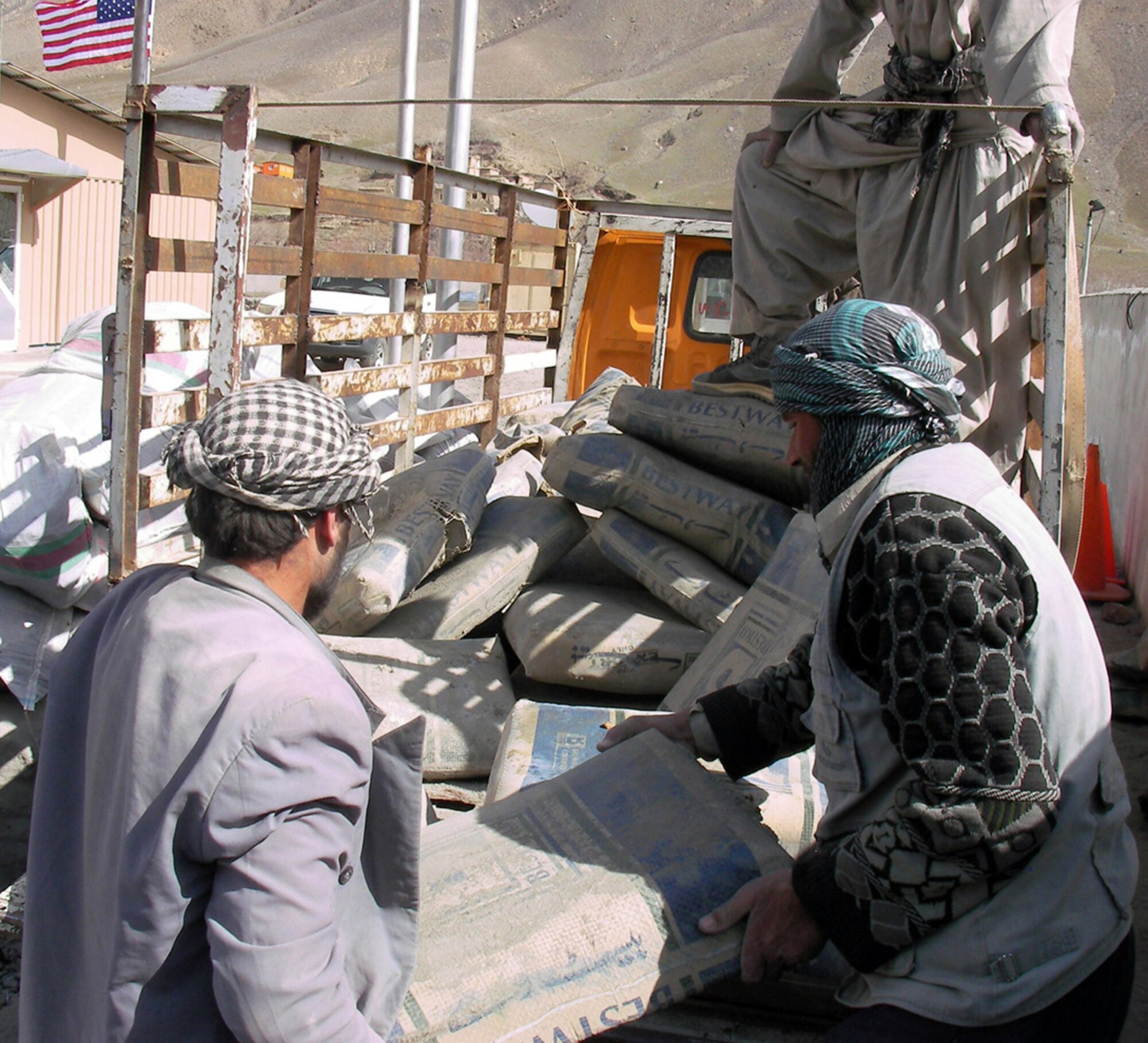 A best practice program developed by the Panjshir Provincial Reconstruction Team has become a community favorite in Panjshir Province, Afghanistan. The program provides construction materials to Afghan locals to complete their own projects. Not all projects are approved and each request meets a stringent review process by the requesting village's provincial council members and the PRT. Villagers pick up bags of cement from the Panjshir PRT headquarters. They complete the project and then engineers inspect the work to ensure the cement was used properly. (U.S. Air Force photo/Capt. Chris White)
