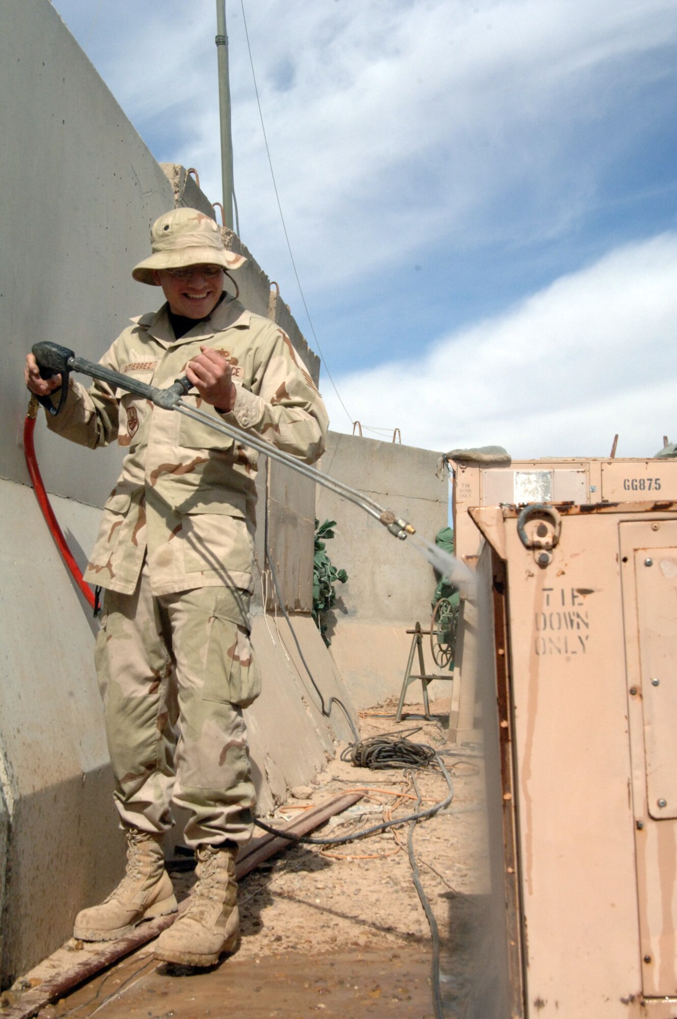 Balad Air Base, Iraq - Staff Sgt. Robert Gutierrez, an Air Ground Equipment (AGE) maintainer, power washes dirt and debris from an air conditioning unit to improve its efficiency and performance at Balad Air Base, Iraq. Sergeant Gutierrez is assigned to the 727th Expeditionary Air Control Squadron (EACS) and is deployed from the 33rd Maintenance Squadron at Eglin Air Force Base, Fla. Also known as Kingpin, the self-sustaining 727th EACS is comprised of nealry 200 Airmen from 27 different Air Force specialties. Air conditioning units like this keep Kingpin's radars, computers and communication equipment cool, allowing its controllers to maintain positive control over aircraft operating in Iraq's 277,000 miles of airspace. (U.S. Air Force photo/Major Damien Pickart)        