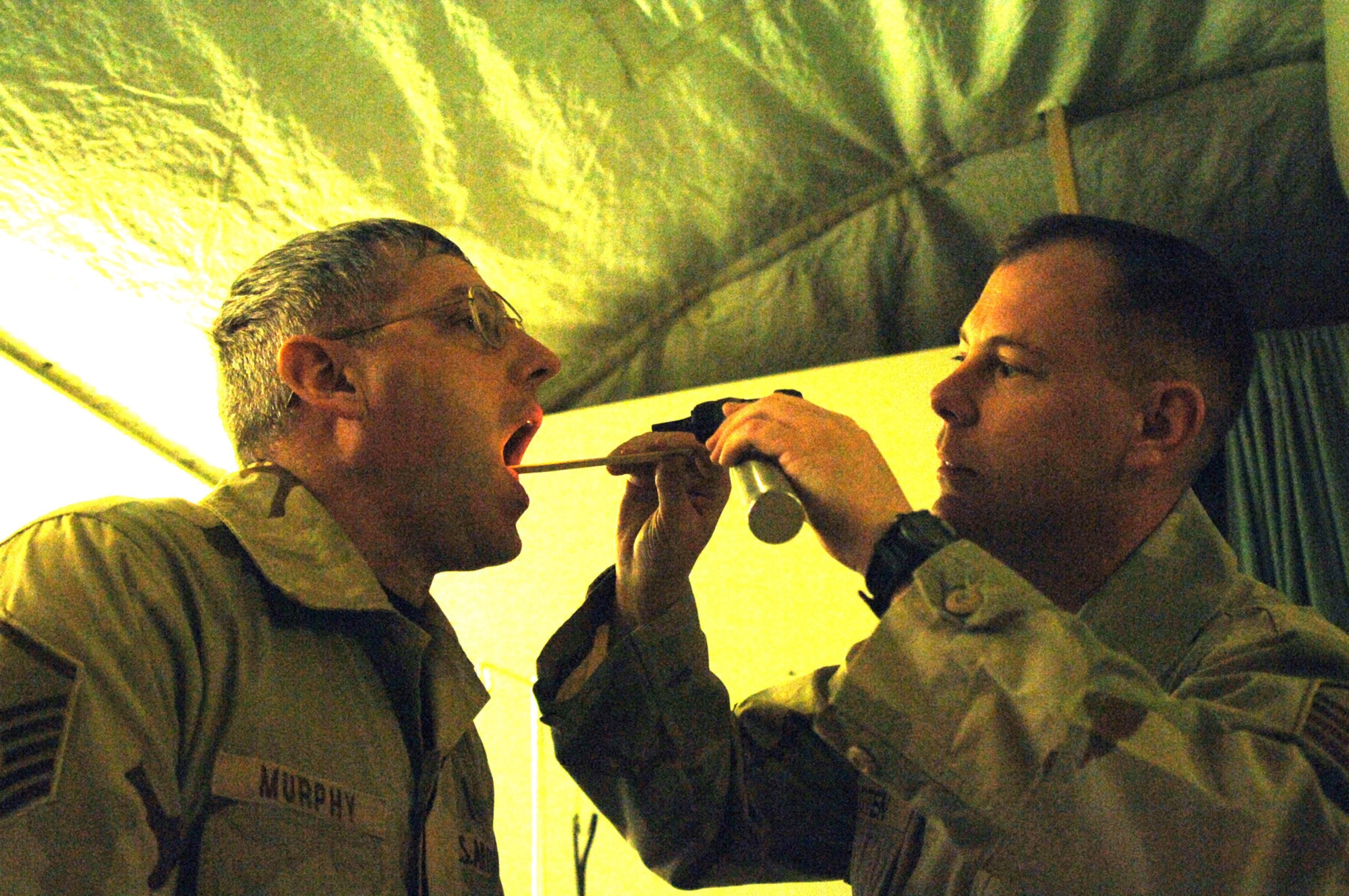 Balad Air Base, Iraq - Master Sergeant Dennis Hooten, a medical technician, performs a medical check up on Master Sgt. James Murphy at Balad Air Base, Iraq. Both Sergeants are assigned to the 727th Expeditionary Air Control Squadron (EACS) and are deployed from the 728th Air Control Squadron at Eglin Air Force Base, Fla. Also known as Kingpin, the self-sustaining 727th EACS is comprised of nealry 200 Airmen from 27 different Air Force specialties, including medical technicians that maintain an on-site clinic. Kingpin is responsible for maintaining positive control over aircraft operating in Iraq's 277,000 miles of airspace. (U.S. Air Force photo/Major Damien Pickart)        