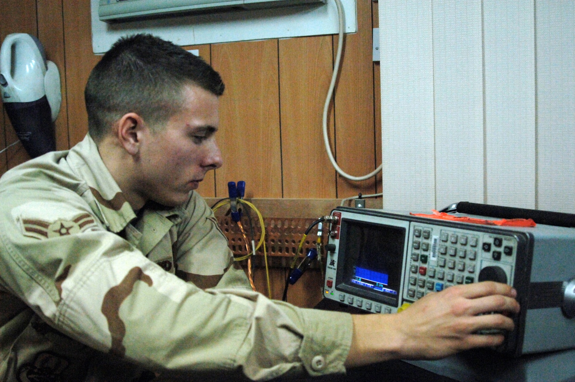 Balad Air Base, Iraq - Airman First Class Nicholas Chase, a satellite wideband and radio maintenance technician, monitors a radio test set to ensure radar controllers' have clear communication with aircrew flying over Iraq in support of OIF. Airman Chase is assigned to the 727th Expeditionary Air Control Squadron (EACS) and is deployed from the 728th Air Control Squadron at Eglin Air Force Base, Fla. Also known as Kingpin, the self-sustaining 727th EACS is comprised of nealry 200 Airmen from 27 different Air Force specialties. Kingpin is responsible for maintaining positive control over aircraft operating in Iraq's 277,000 miles of airspace. (U.S. Air Force photo/Major Damien Pickart)        