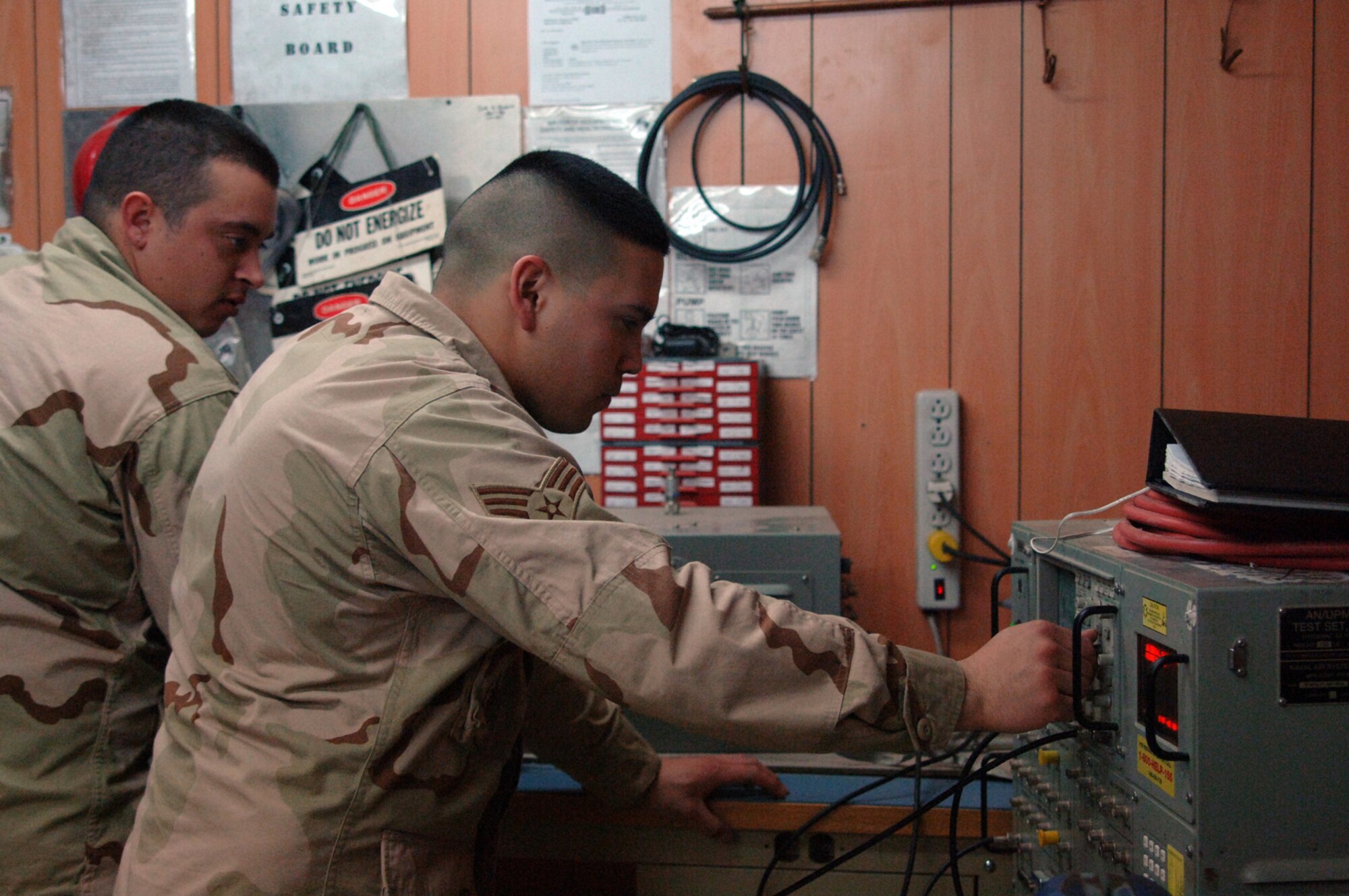 Balad Air Base, Iraq - Senior Airmen Jason Gleason and Charles Storr, both radar technicians, bench check a UPX-27 Interrogator, a key component of the Identify Friend or Foe (IFF) system, which challenges and identifies aircraft. Both Airmen are assigned to the 727th Expeditionary Air Control Squadron (EACS).  Airman Gleason is deployed from the 728th Air Control Squadron (ACS) at Eglin Air Force Base, Fla. Airman Storr is a volunteer augmentee from the 603rd ACS, Aviano Air Base, Italy. Also known as Kingpin, the self-sustaining 727th EACS is comprised of nealry 200 Airmen from 27 different Air Force specialties. Kingpin is responsible for maintaining positive control over aircraft operating in Iraq's 277,000 miles of airspace. (U.S. Air Force photo/Major Damien Pickart)        