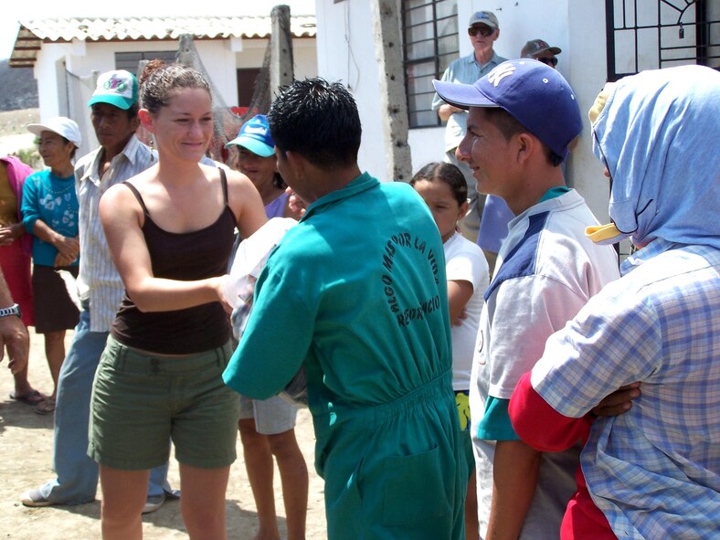 First Lt. Emily Cole hands out compassion packages to residents of the Manta City Dump in Ecuador. She is assigned to the Air National Guard's 157th Air Refueling Wing at Pease, N.H. (U.S. Air Force photo/Maj. Chris Hemrick)