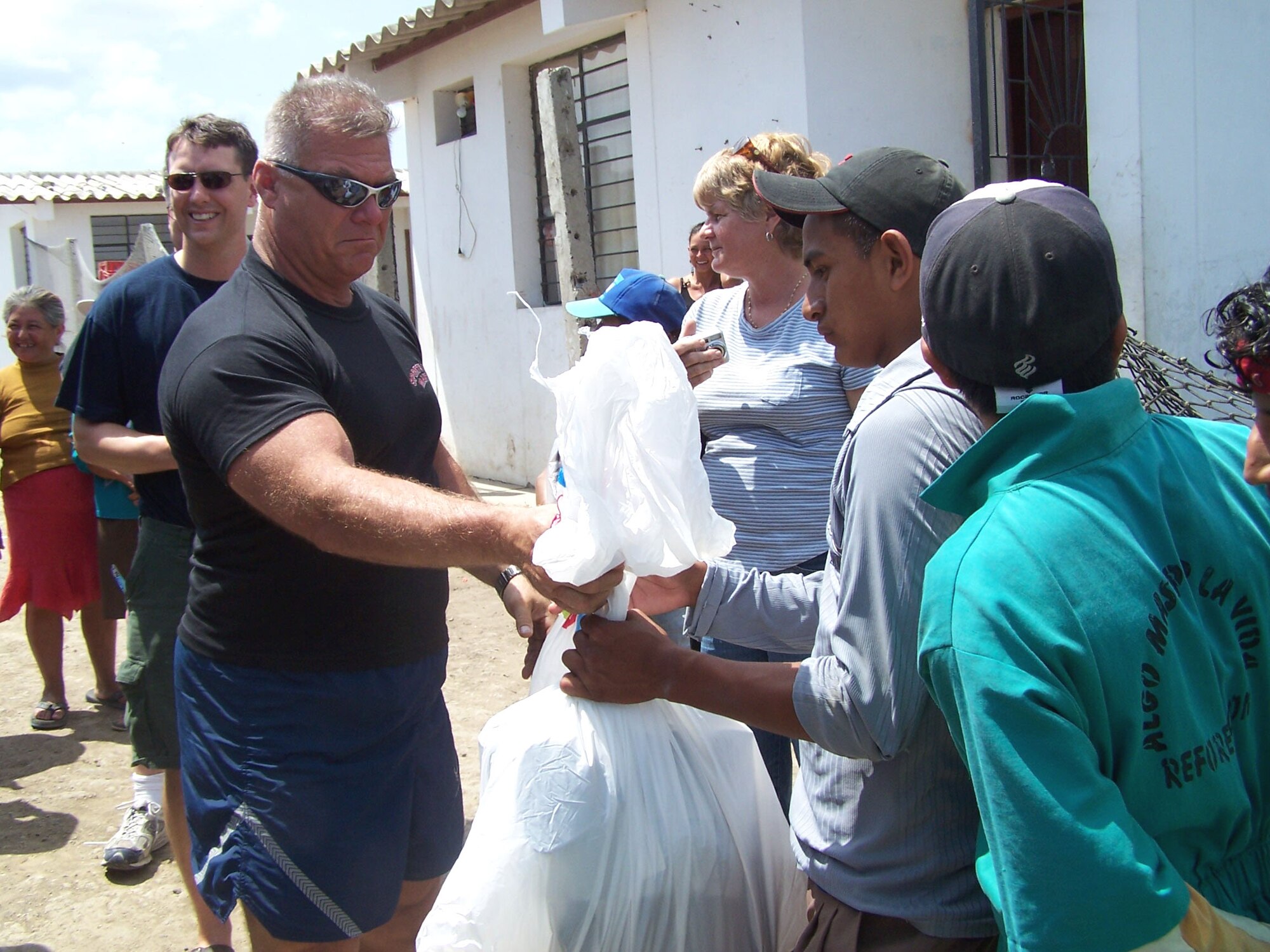 Chief Master Sgt. Bruce Nicholson hands out compassion packages to residents of the Manta City Dump in Ecuador. He is assigned to the Air National Guard's 157th Air Refueling Wing at Pease, N.H. (U.S. Air Force photo/Maj. Chris Hemrick) 

