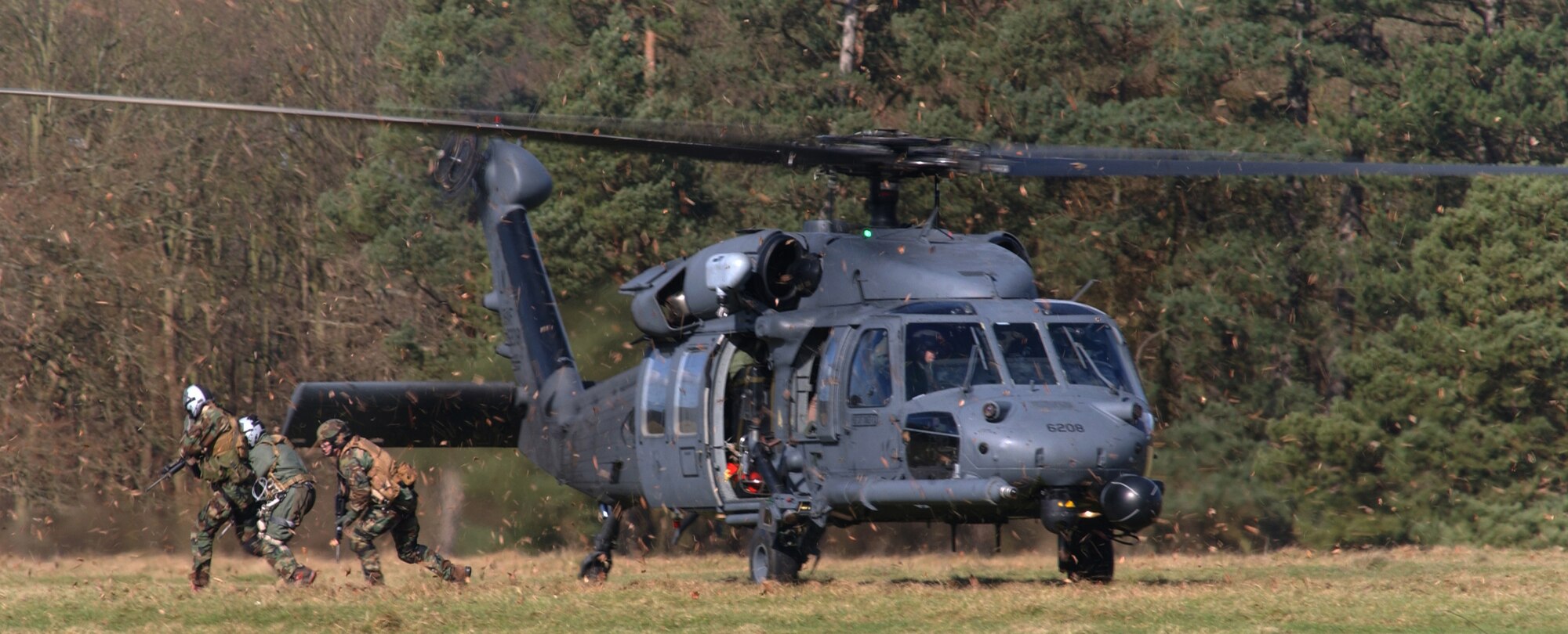 Members of the 56th Rescue Squadron from RAF Lakenheath perform a mock rescue scenario during a combat survival training event at Stanta Training Range near Thetford, England March 6. (U.S. Air Force photo by Airman Brad Smith)                               