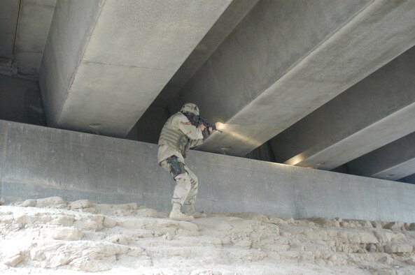 CAMP BUCCA, Iraq -- Staff Sgt. Mark Bentoski, 586th Expeditionary Security Forces Squadron Vehicle Commander, searches under a bridge for Improvised Explosive Devises near Safwan, Iraq, October 2006. Safwan has a history of being a hot bed of IED activity. (AF photo/ Staff Sgt. Ian Carrier)                               