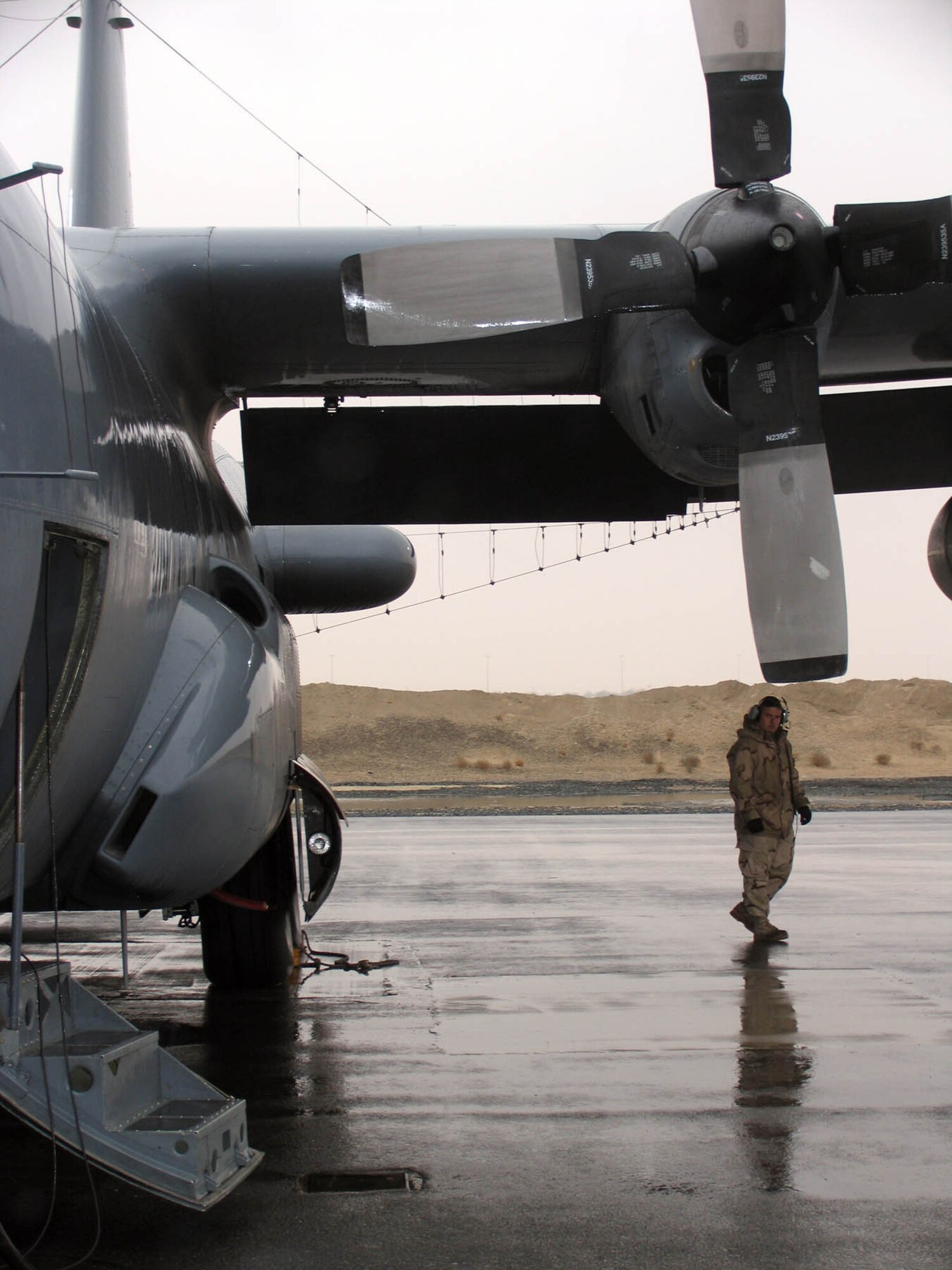 SOUTHWEST ASIA -- SSgt Michael D. Anderson, 43rd Expeditionary Electronic Combat Squadron EC-130H Crew Chief, performs the preflight walkaround inspection prior to launch. The mission the plane took part in took the Compass Call aircraft of the 43 EECS, 386th Air Expeditionary Wing over 10,000 combat hours. The 43 EECS has been in theater since March, 2004. (AF photo Staff Sgt. Ian Carrier)
