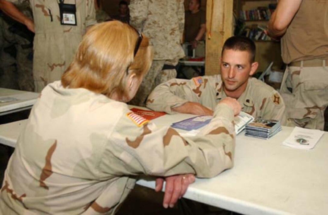 Kathleen Connelly, left, education services officer, discusses different college options with Army Spc. Brian King, 2nd Battalion, 265th Air Defense Artillery Regiment, during the Army and Air Force Exchange Service rodeo in mid-July at Forward Operating Base Asadabad, Afghanistan. Representatives from the Army Reserve Affairs, retention and the Army Continuing Education System offices join the rodeo to answer any questions service members might have. Photo by Staff Sgt. Monica R. Garreau, USA 
