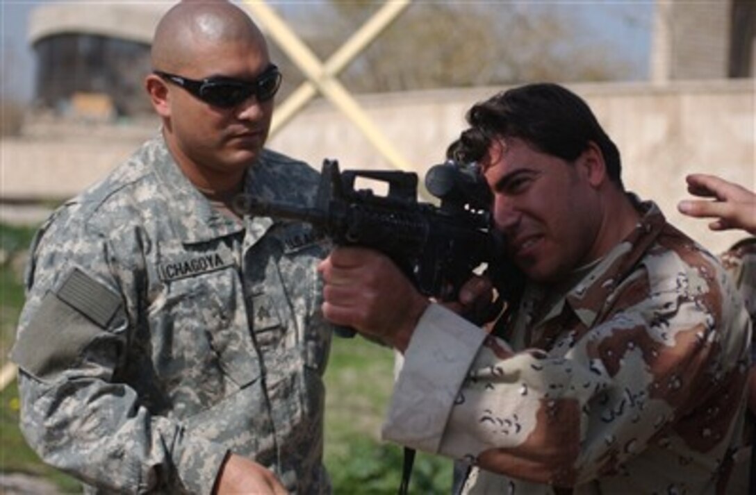 U.S. Army Sgt. Ely Chagoya (left) assists an Iraqi army soldier with correct body positioning for clearing a room during a class at Forward Operating Base Apache, Iraq, on Feb. 28, 2007.  Chagoya is a squad leader from Charlie Company, 1st Battalion, 26th Infantry Regiment.  