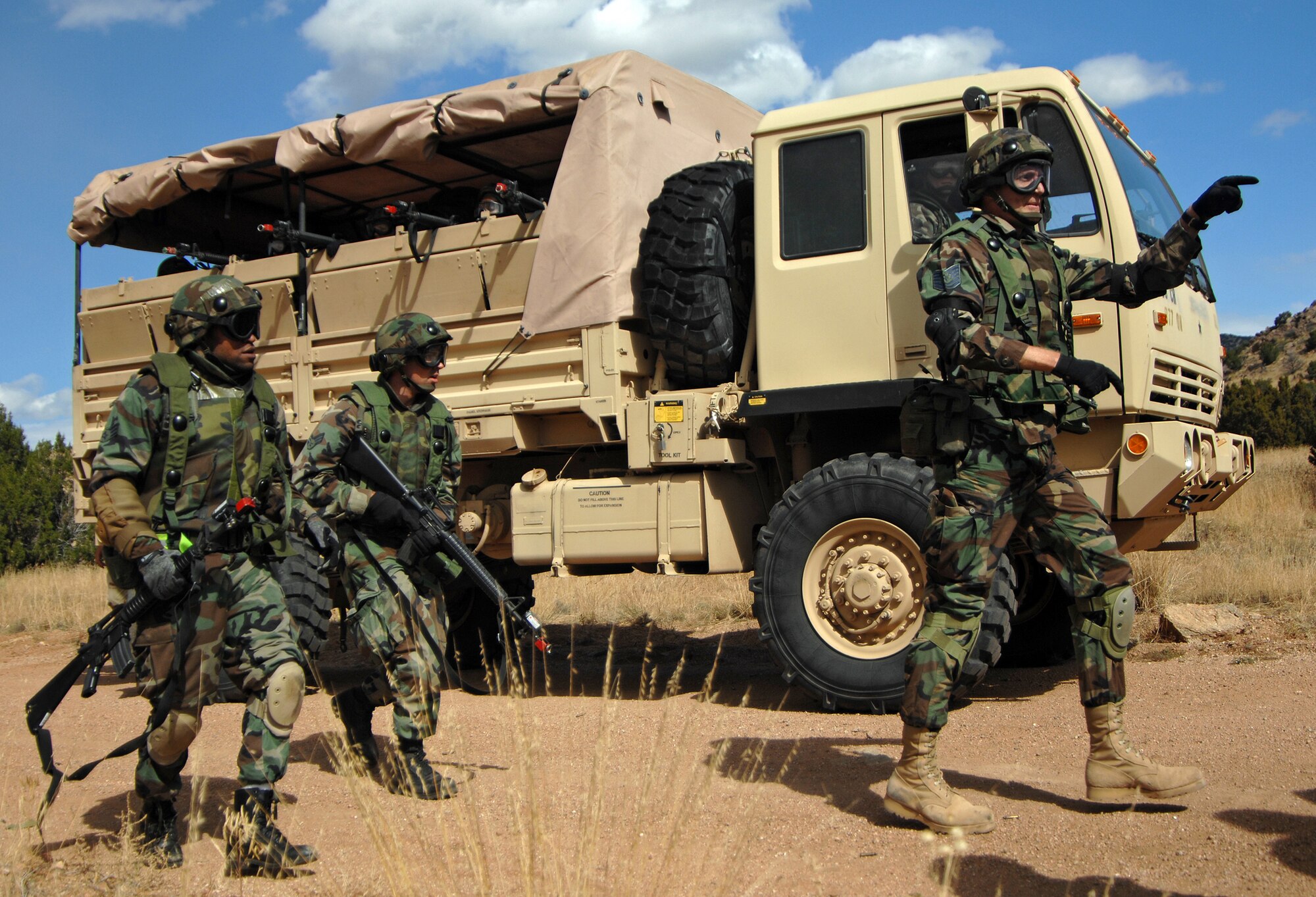 Tech. Sgt. Nicholas McKinley (pointing), a paralegal with the 377th Air Base Wing legal office here, acts as a convoy commander during a combat skills training exercise. While deployed, legal office personnel could be doing anything from transporting files from camps to courts, accompanying detainees or picking up court workers. (U.S. Air Force photo)
