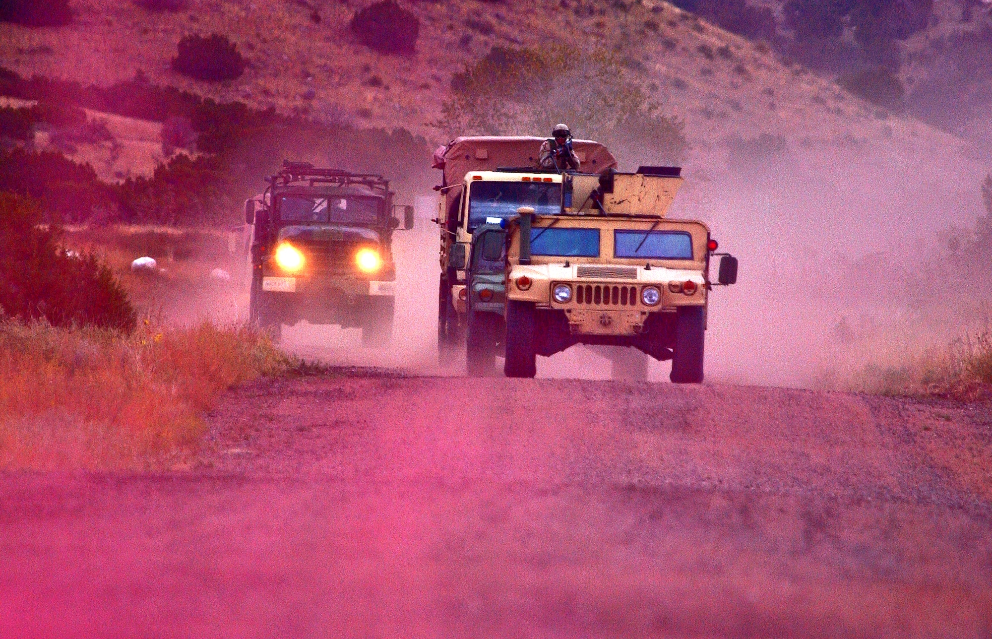 Capt. Thomas Menza, 377th Air Base Wing legal office, mans a turret on the lead vehicle of a convoy during a combat skills training course held here. The purple color is from smoke used to simulate combat conditions. (U.S. Air Force photo)                           