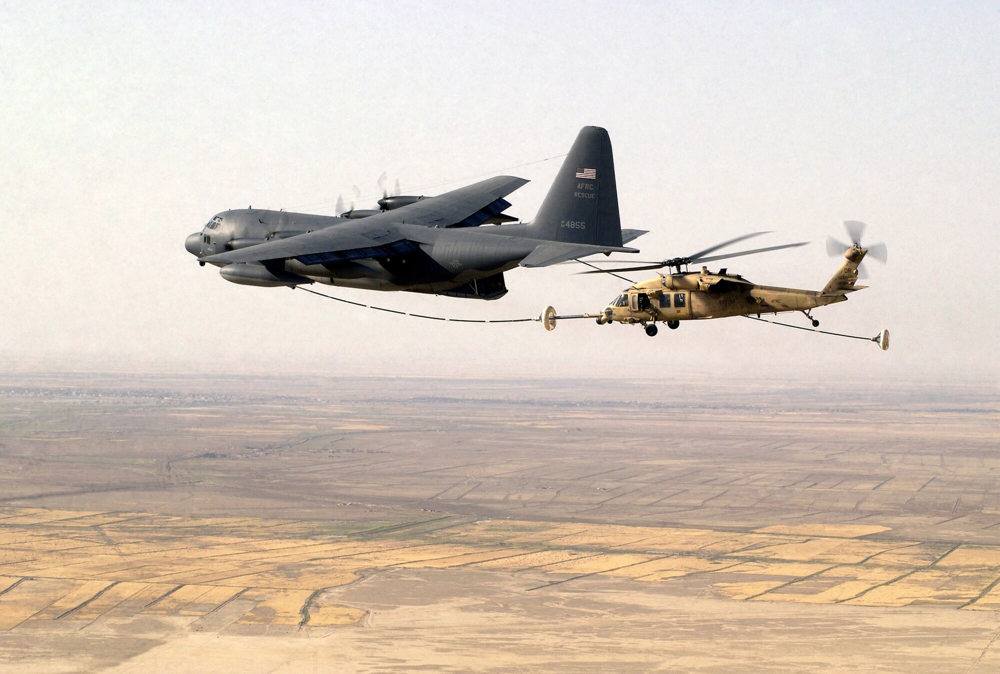 A US Air Force Reserve HH-60G Pave Hawk search and rescue helicopter assigned to the 301st Rescue Squadron, conducts in-flight refueling with a Air Force Reserve Command HC-130 Hercules tanker aircraft from the 39th Rescue Squadron, during a mission over Tallil Air Base, Iraq, during Operation Iraqi Freedom (U.S. Air Force photo/Staff Sgt. Shane Cuomo)