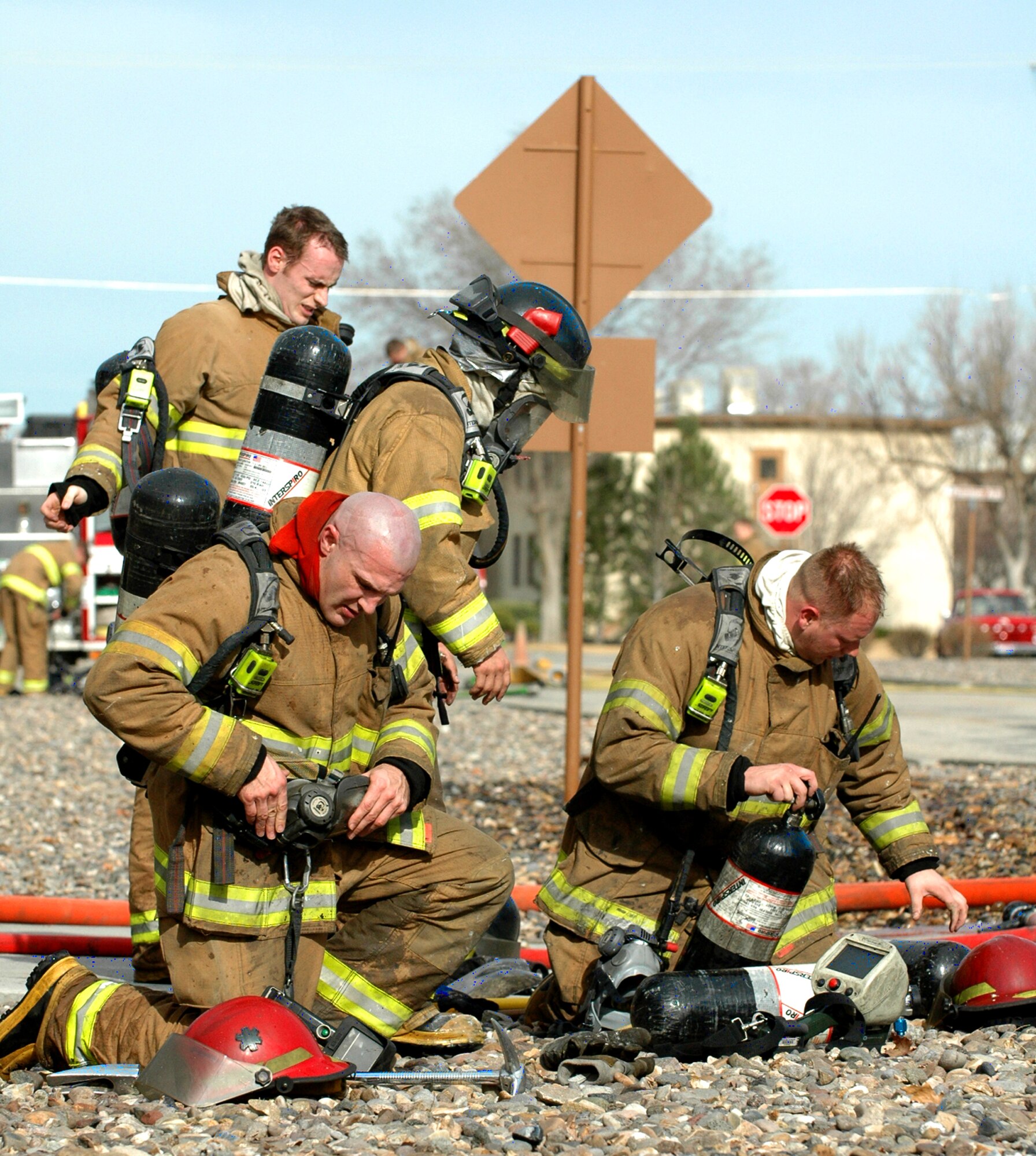 MOUNTAIN HOME AIR FORCE BASE, Idaho -- Firefighters from the 366th Civil Engineer Squadron remove their gear after a live fire exercise March 12 at Bldg. 1612. Environmental tests taken after the small-scale fire will determine if the building is approved for larger scale controlled burns over coming weeks. The structure, previously scheduled for demolition, is helping firemen test their skills in ventilation, search and rescue and forcible entry exercises.  Air Force photo by Airman 1st Class Ryan Crane