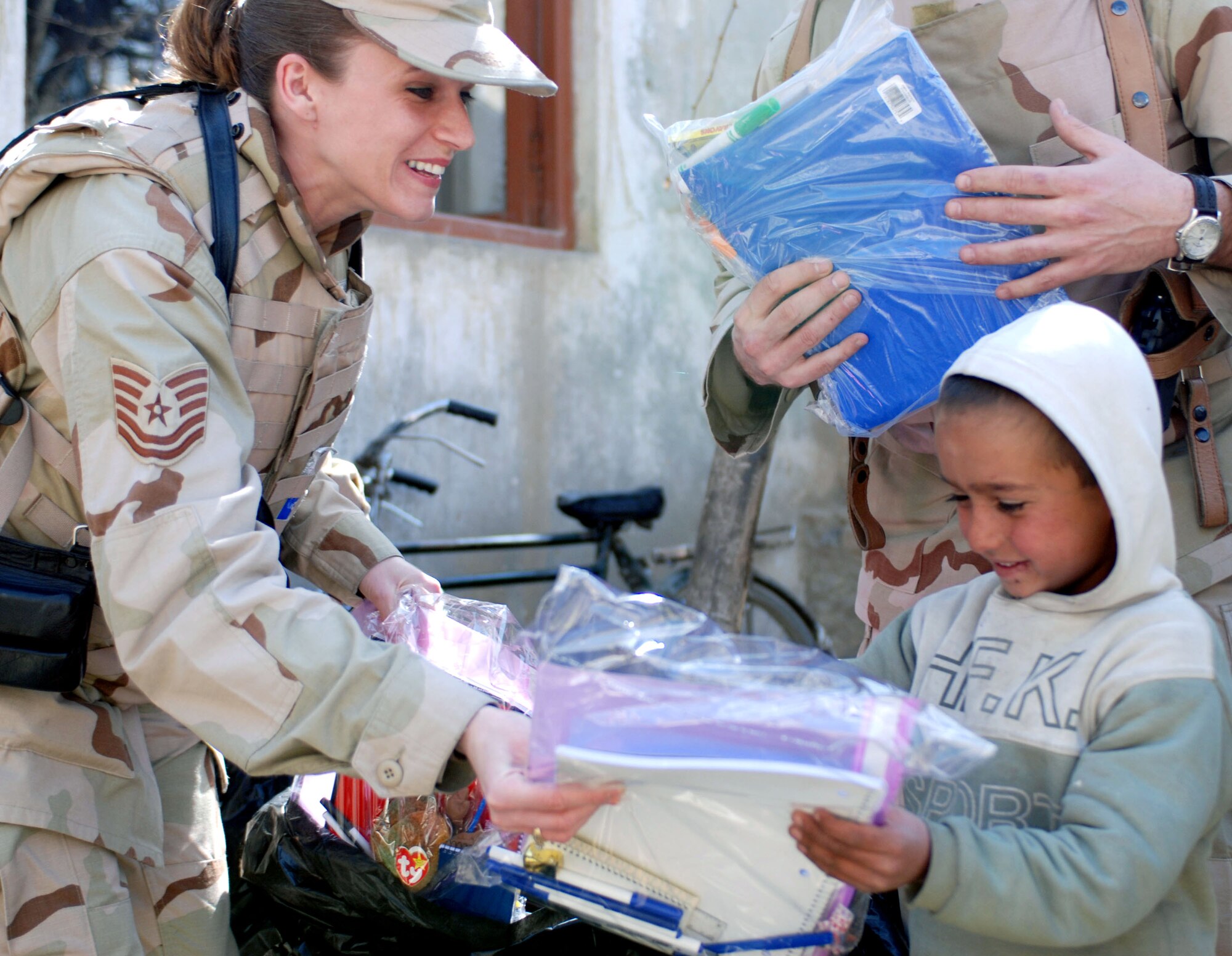 Tech. Sgt. Shelly Ward distributes school supplies to children March 8 at a school in downtown Kabul, Afghanistan. Sergeant and other volunteers from the Combined Security Transistion Command volunteered in the community relations trip sponsored by coalition forces. (U.S. Air Force photo/Senior Airman Stacia Zachary)