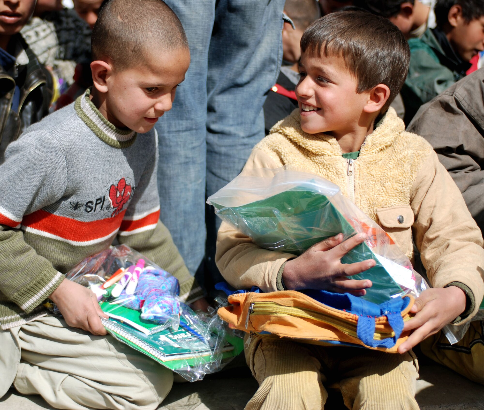 Afghan children from a school in downtown Kabul, Afghanistan get excited over the school supplies donated from coalition forces March 8. Airmen and Marines assigned to the Combined Security Transition Command were part of the community relations visit. (U.S. Air Force photo/Senior Airman Stacia Zachary) 
