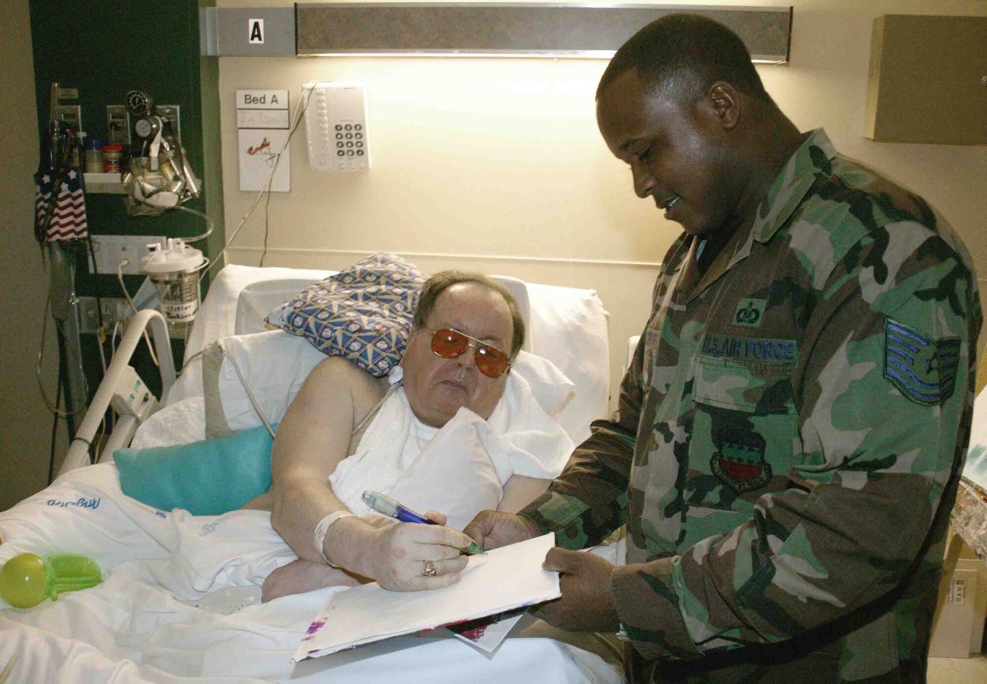 COLUMBIA, S.C. -- Mr. Gerald Jackson autographs a photocopy of one of his art pieces for Tech. Sgt. Dexter Woodruff, 20th Fighter Wing status of resources and training systems manager, during a March 2 visit by Airmen from Shaw Air Force Base, S.C. Mr. Jackson, who loves to paint and talk to visitiors, is one of 57 veterans living in the Veterans' Affairs Dorn Hospital in Columbia. (U.S. Air Force photo/Senior Airman John Gordinier)