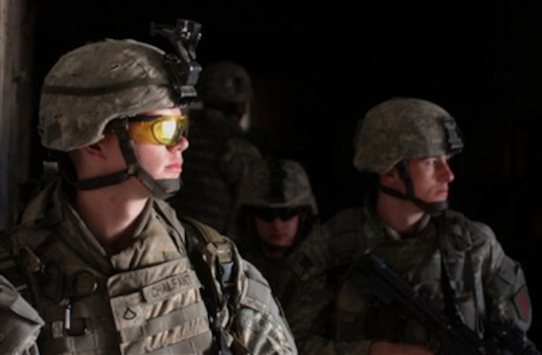 U.S. Army soldiers from Charlie Company, 1st Battalion, 26th Infantry Regiment, 2nd Brigade Combat Team, 1st Infantry Division take cover in a building before moving toward their next objective as the conduct a cordon and search operation in Al Adhamiya, Iraq, on Feb. 21, 2007.  