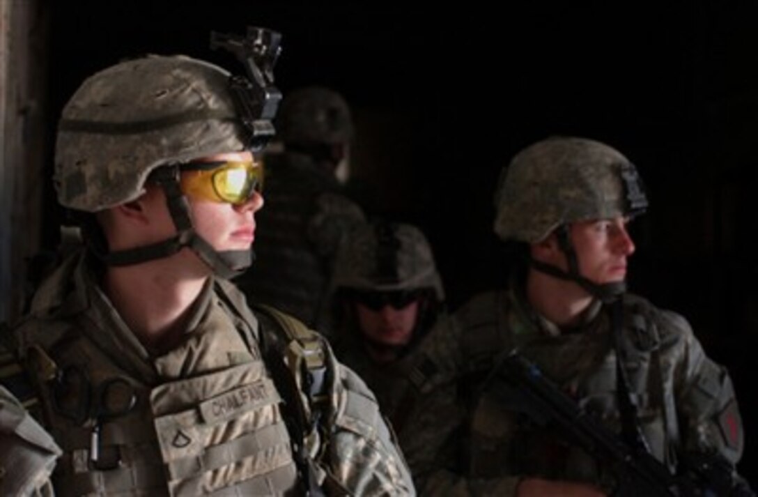 U.S. Army soldiers from Charlie Company, 1st Battalion, 26th Infantry Regiment, 2nd Brigade Combat Team, 1st Infantry Division take cover in a building before moving toward their next objective as the conduct a cordon and search operation in Al Adhamiya, Iraq, on Feb. 21, 2007.  