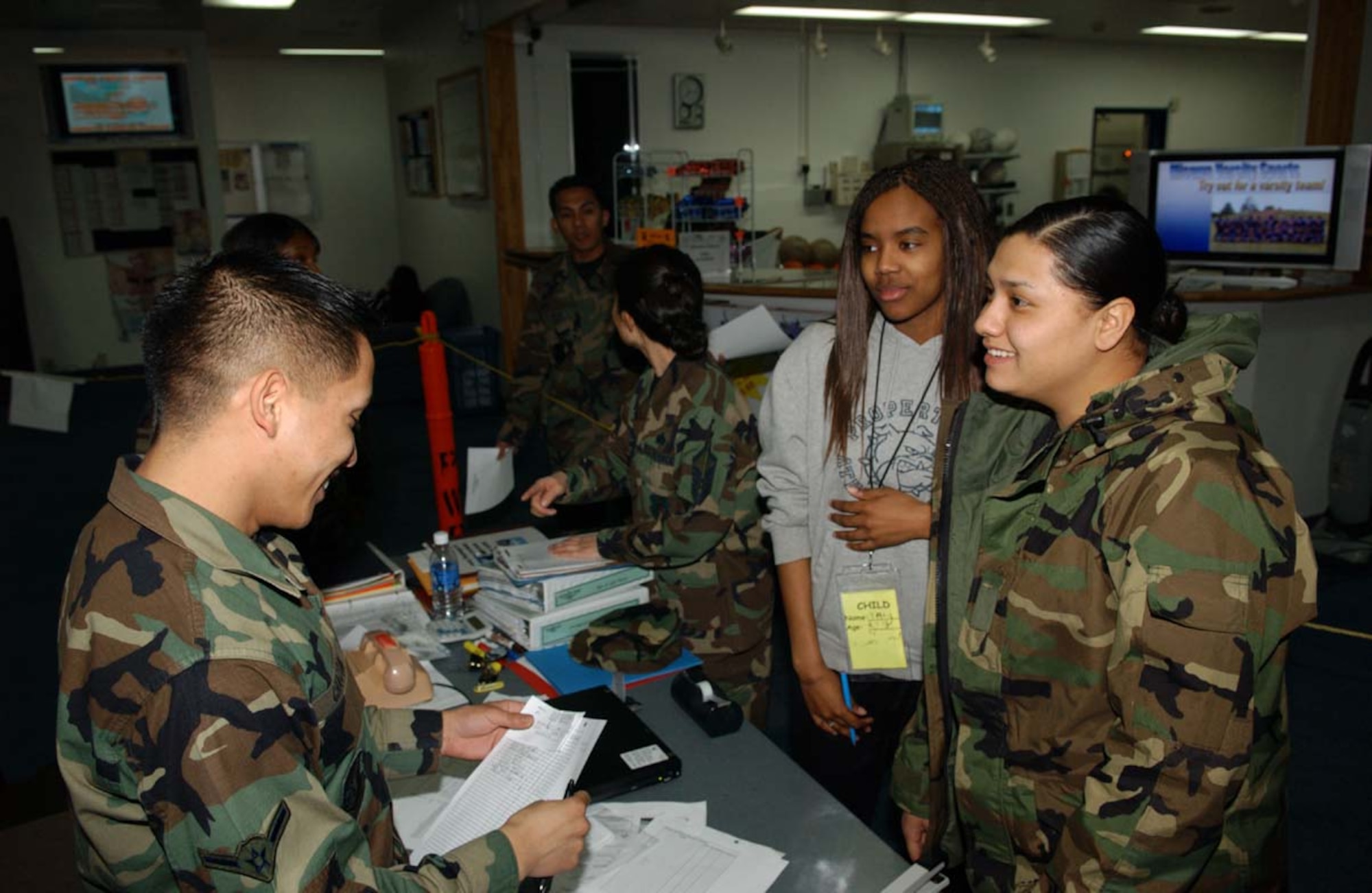 070312-F-0108B-003 MISAWA AB, JAPAN --  Airman Kristoffer Chacon, a noncombatant evacuation operation agent, (left) processes simulated evacuees Senior Airman Tamisha Rutledge (center) and Airman First Class Danielle Escorza (right) during phase one of Misawa Air Base's Operational Readiness Inspection in the Potter Fitness Center, a imulated alternate inn, March 12, 2007.  The ORI is designed to make sure the Airmen are ready and able to respond to any combat scenario.
(U.S. Air Force photo by Senior Airman Robert Barnett)